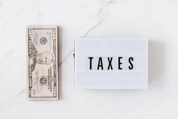 Taxes sign and US dollars, related to tax reduction for divorce law firms