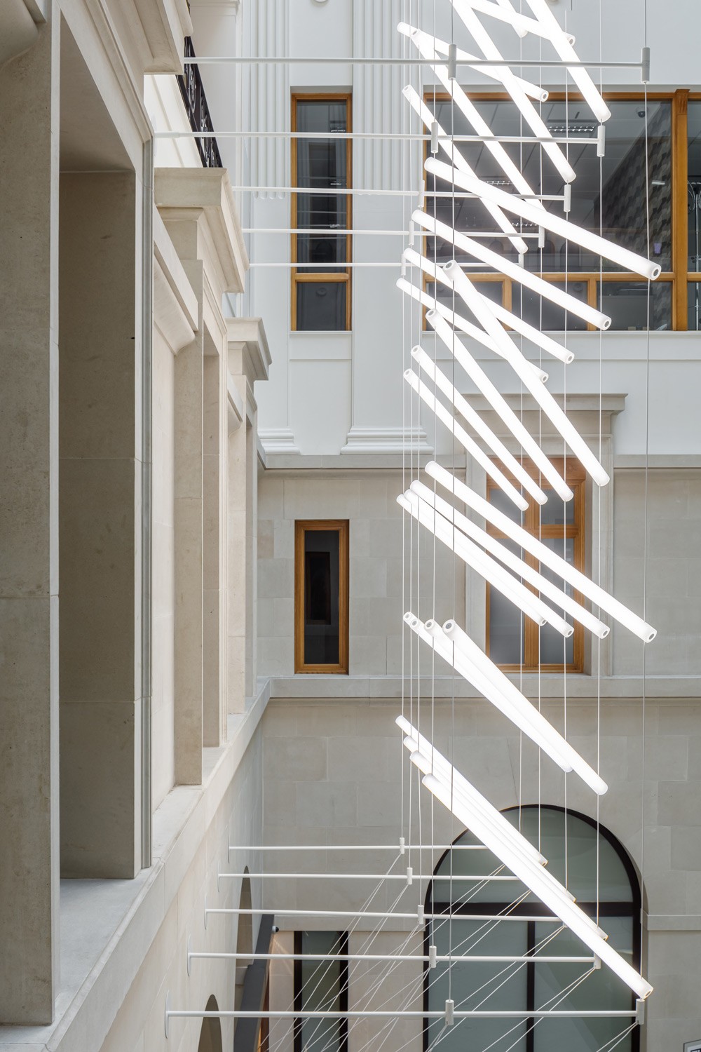 Side view of lighting installation showing grid of steel cables and illuminated acrylic elements
