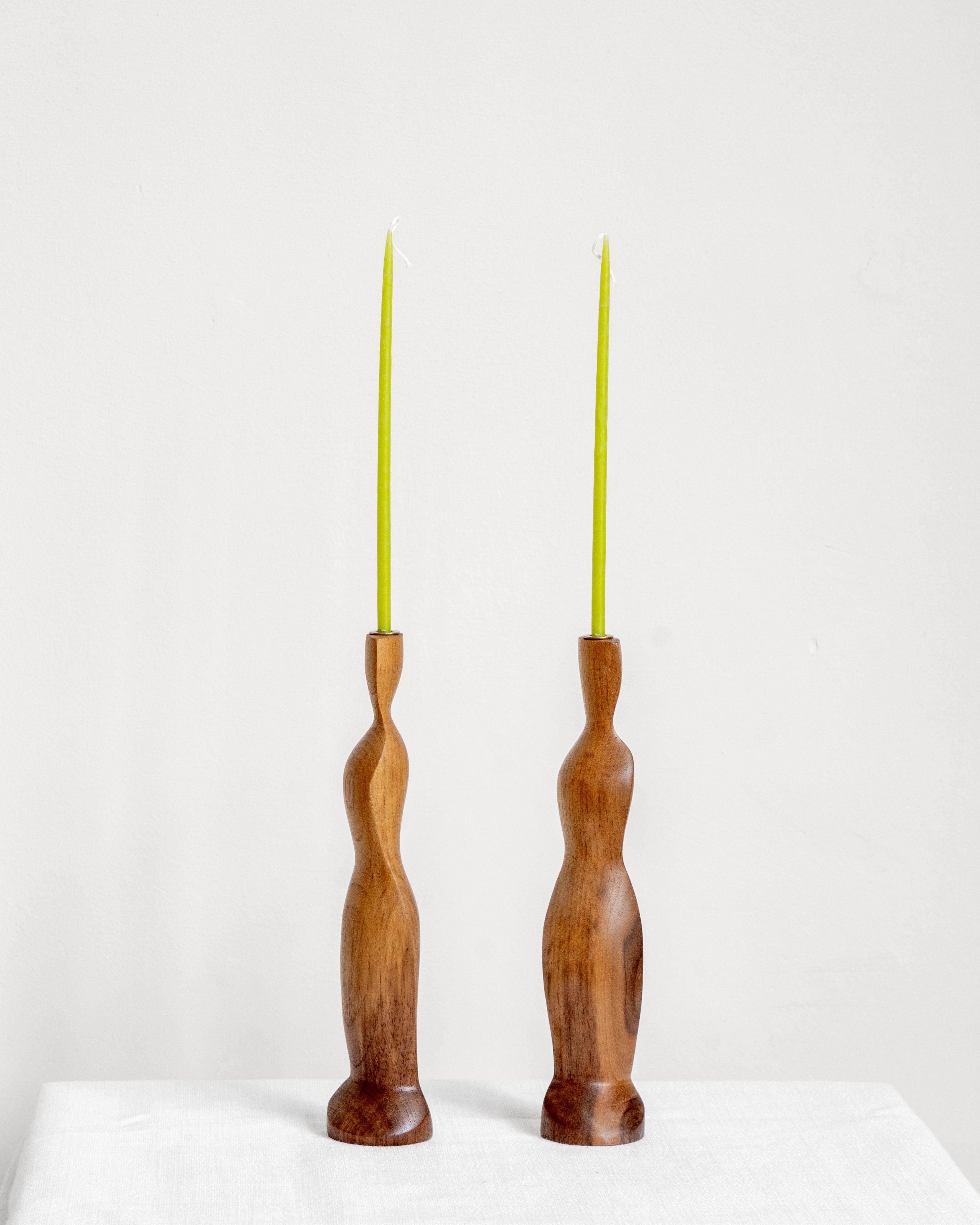 Figura Candlestick holders in Walnut on white background with green candles