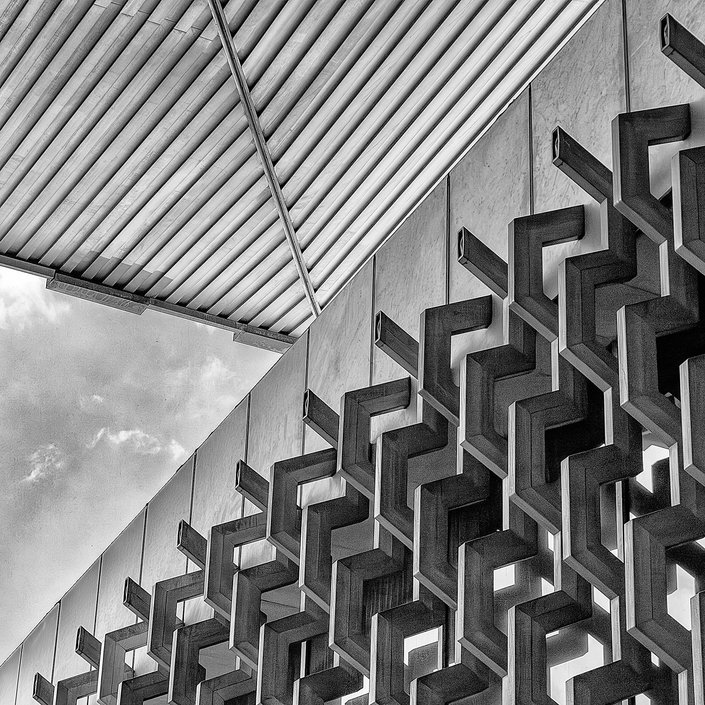 Black and white photo of the Museo Nacional de Antropología in Mexico City, featuring its iconic geometric facade and angular roof structure.