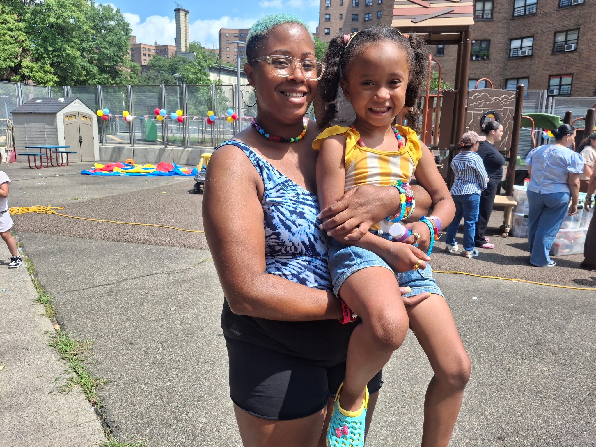 A parent and young child enjoying a block party.