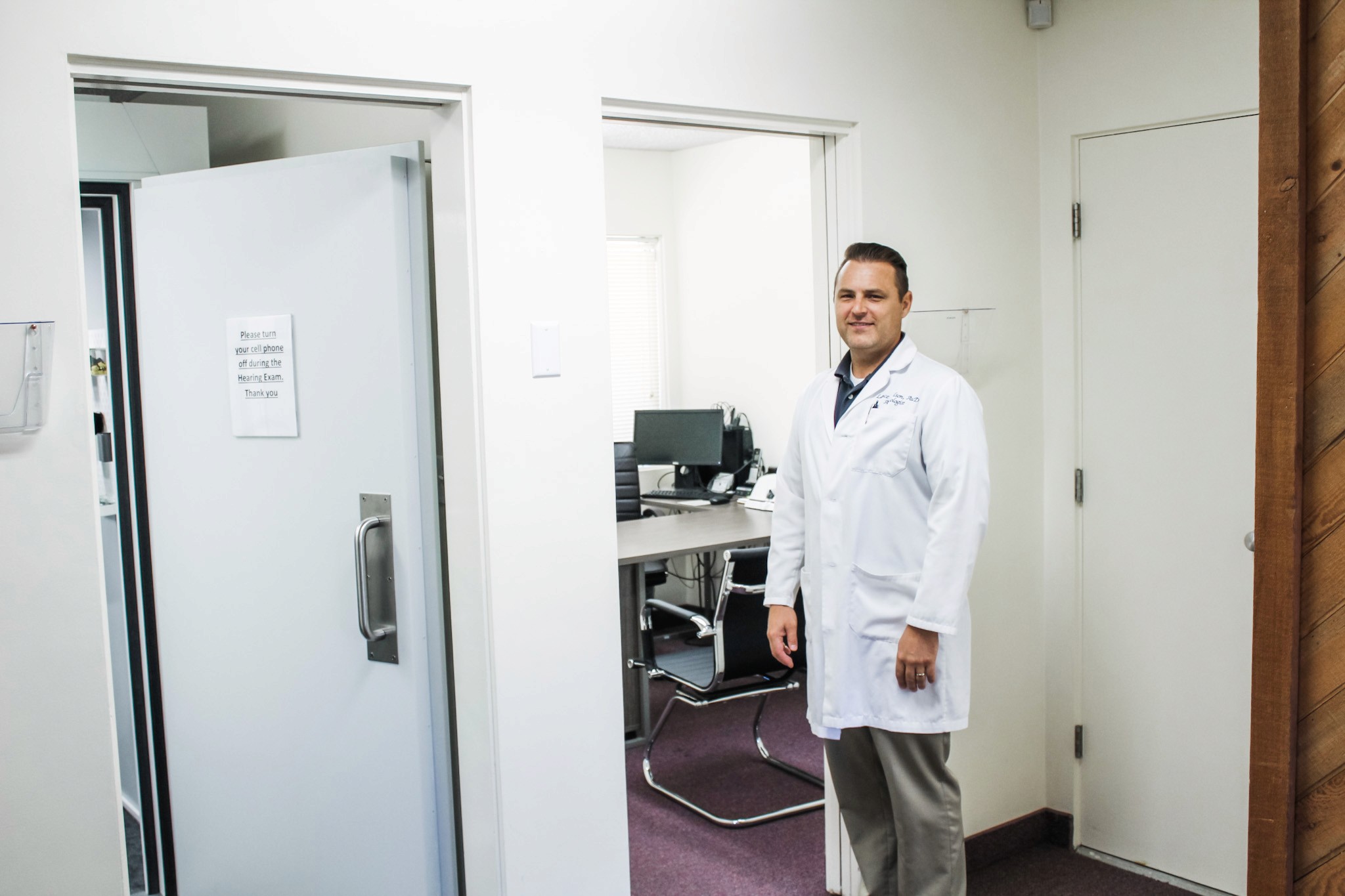 Man sitting in a testing booth having a hearing test