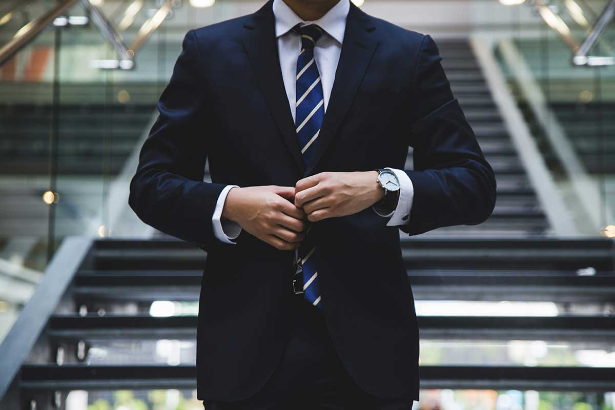 Professional man in a suit adjusting his jacket, symbolizing confidence and dedication to legal excellence.