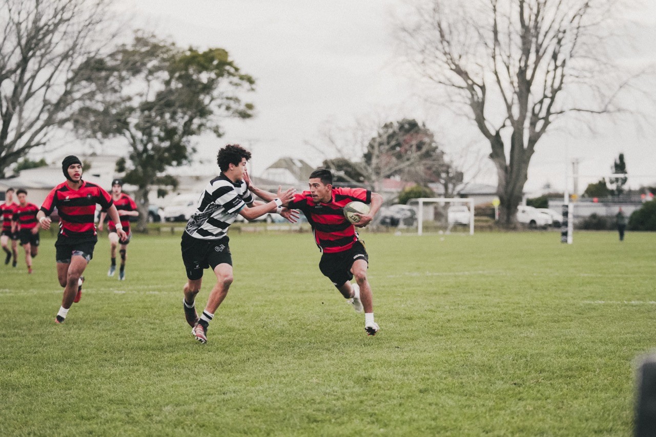 Rugby player stiff arming an opponent