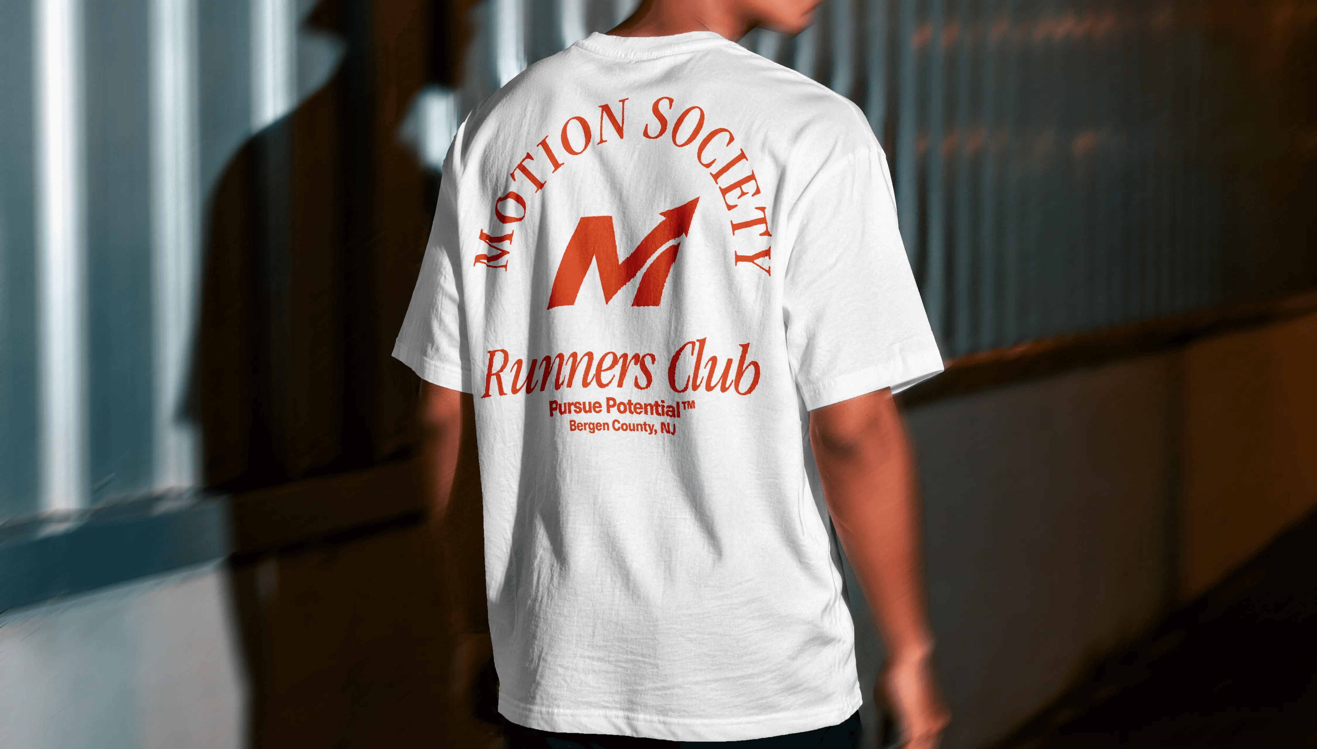White Motion Society Runners Club t-shirt, back print with M-arrow badge design.