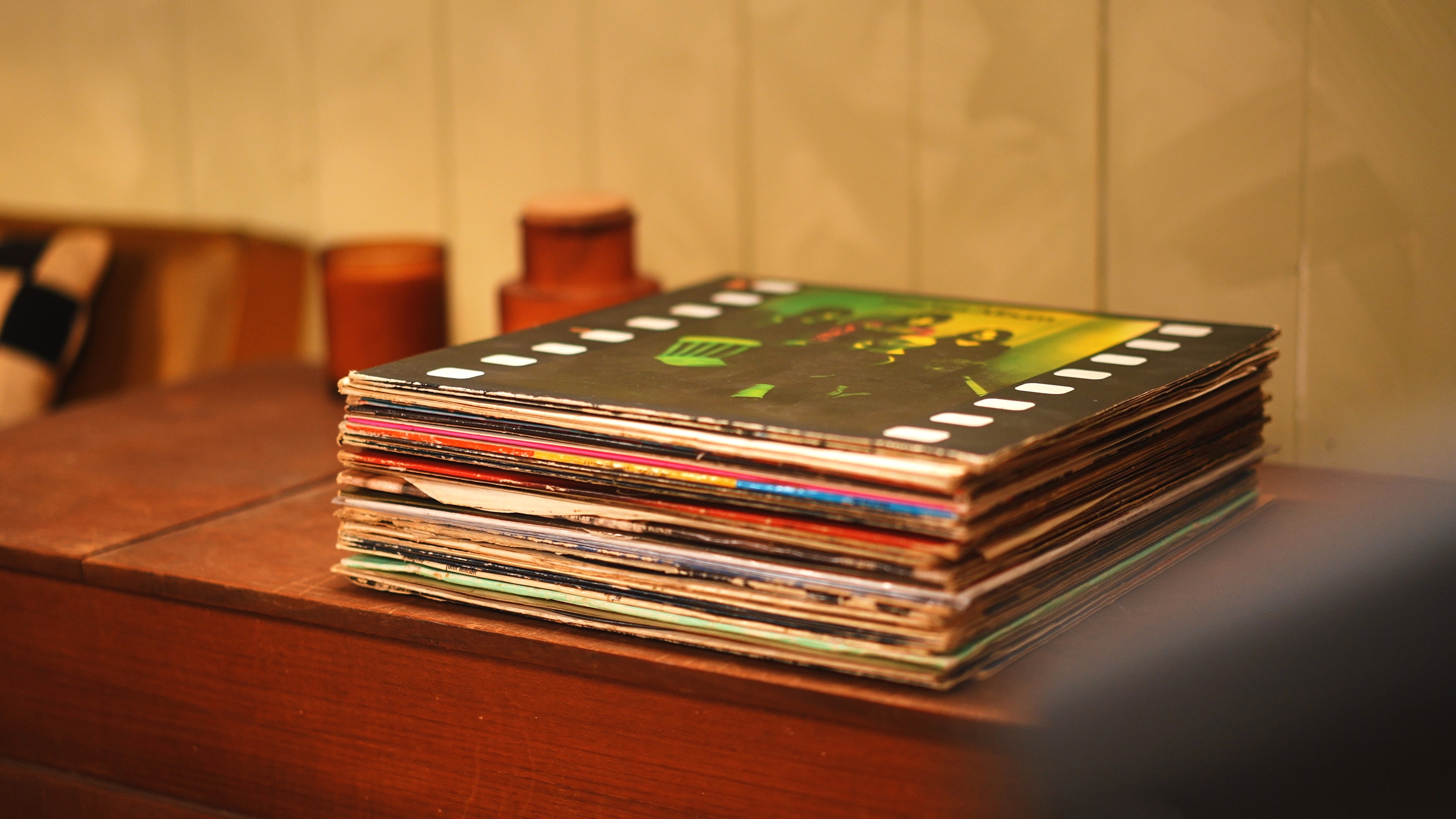 Rammed-earth space with curved walls, wooden seating, and soft daylight from a tall window.