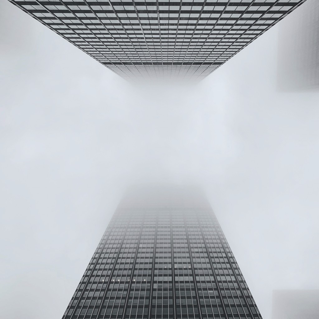 black white image of a hall with white walls and metal grid roof and floor.