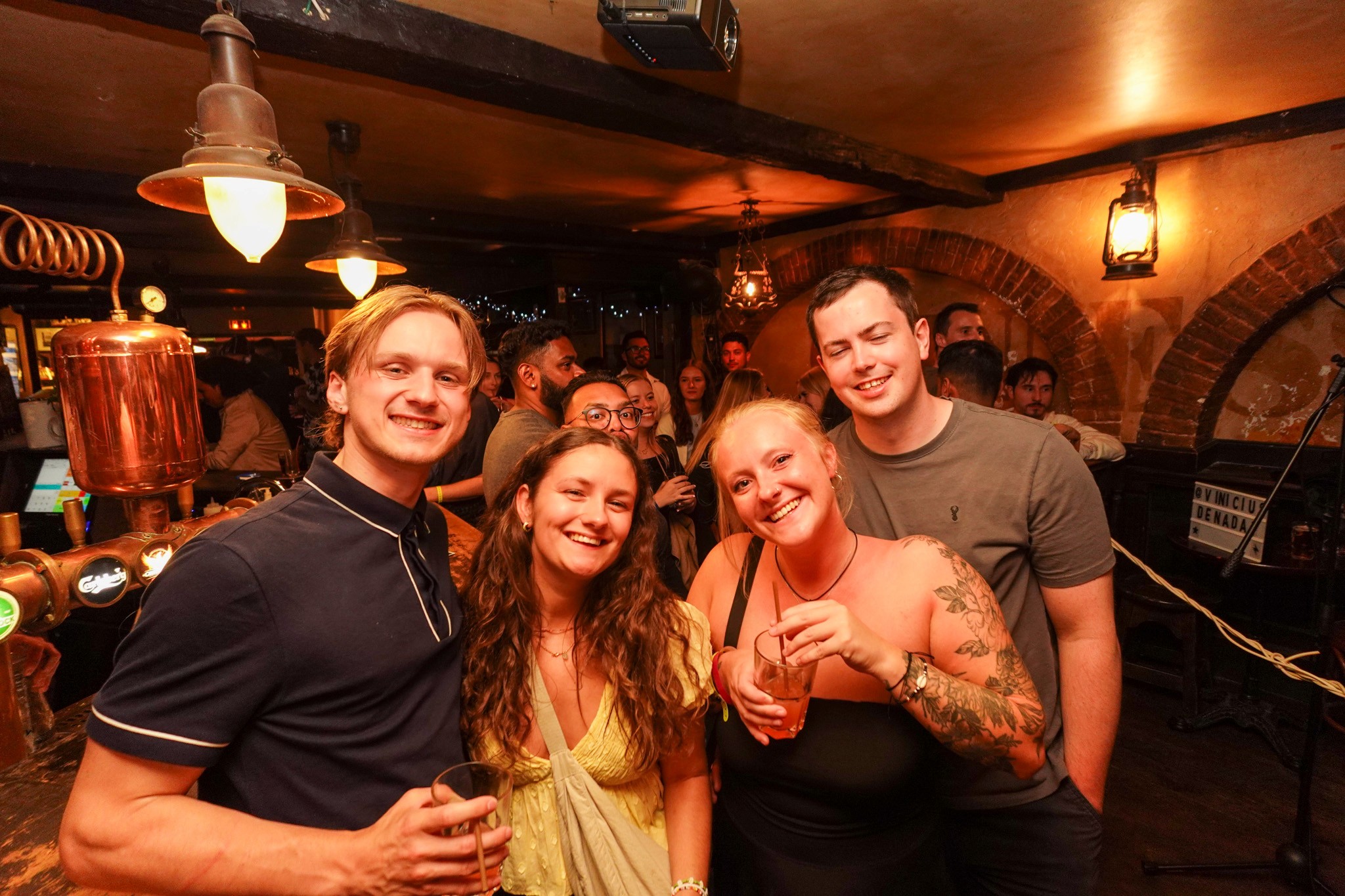 Backpackers enjoying nightlife in Nice, chatting in lively bars and walking through illuminated Old Town streets at night.