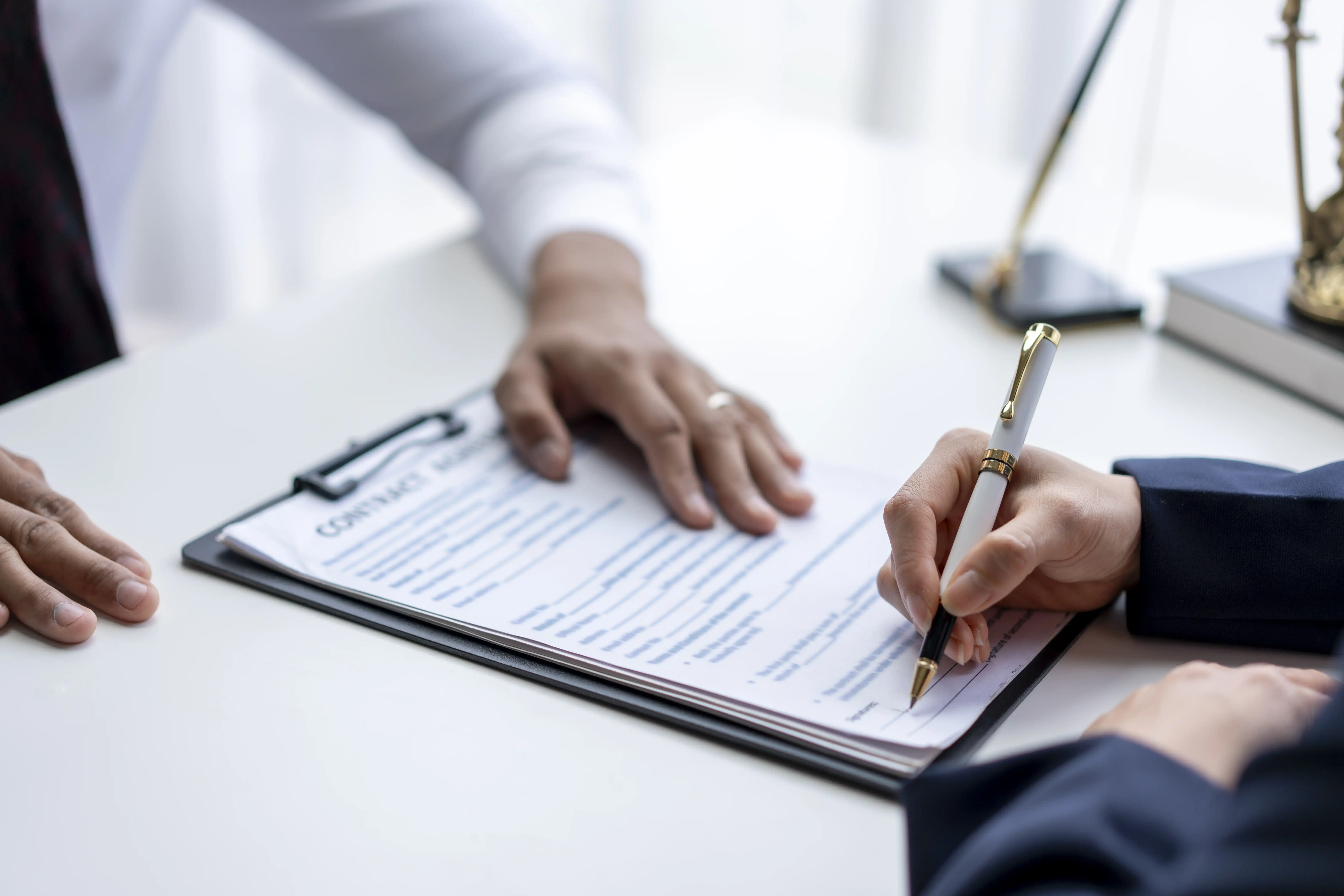 Employee signing an employment contract clipboard, representing legal reviews of mandatory arbitration agreements in California wage and hour claims
