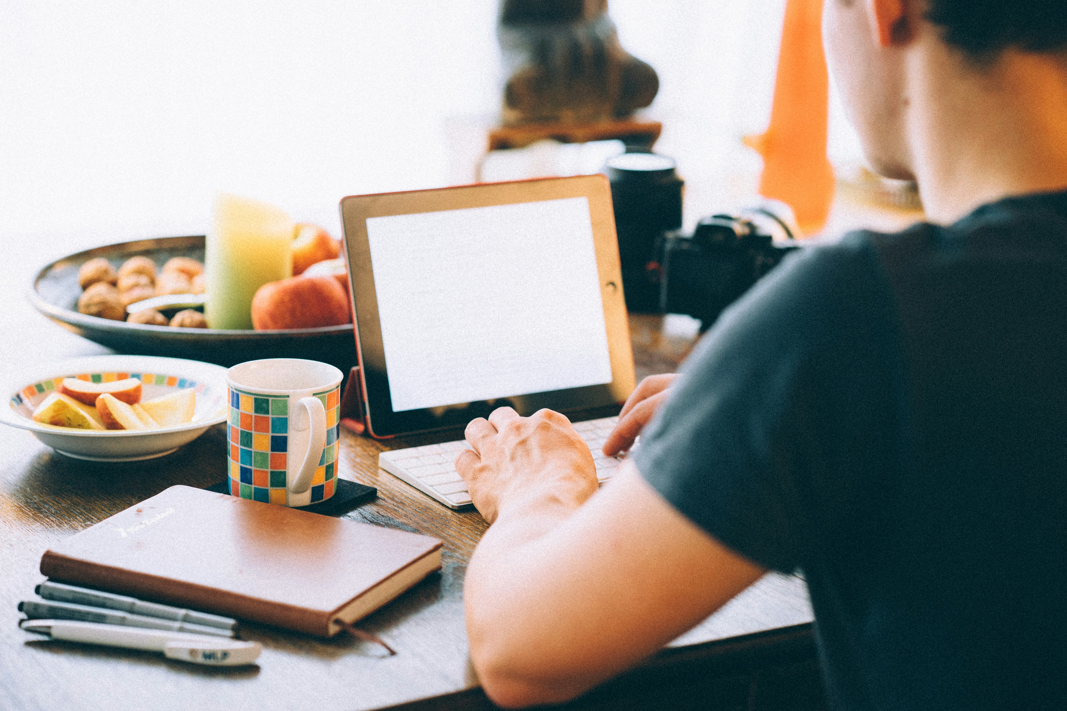 person writing on a dinner table - How To Overcome Writer's Block Essay