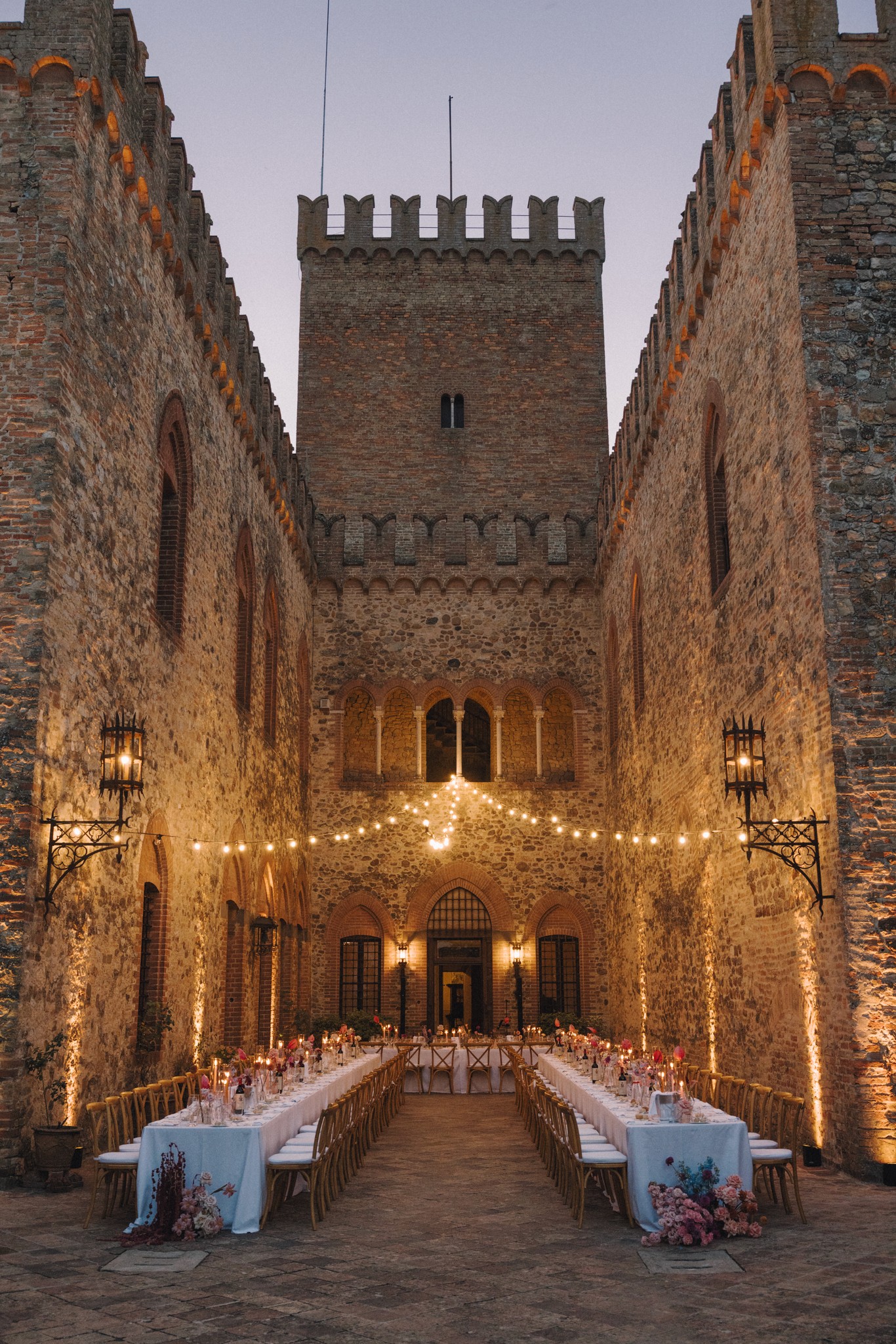 Ricevimento matrimoniale al Castello di Tabiano, tavolate illuminate entro le mura medievali della rocca