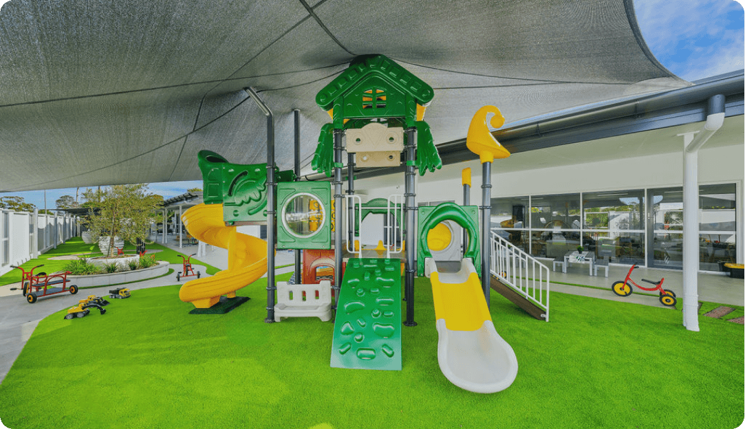 Outdoor playground at Kaleidoscope Kids Rothwell featuring slides, climbing equipment, and shaded play areas for children.