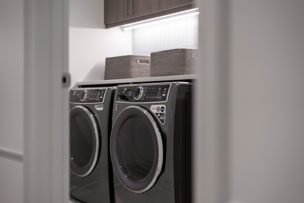Clean laundry room with a washer and dryer, where a clogged dryer vent is a hidden fire risk