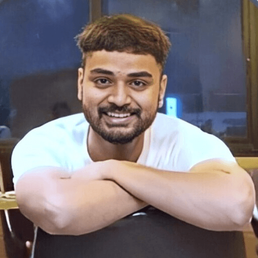 Portrait of a person in a pink sweater against a light background