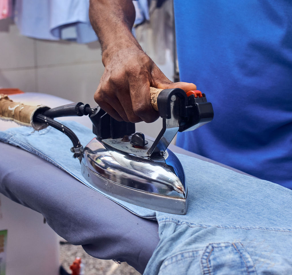 a black and white photo of a man moving a rug