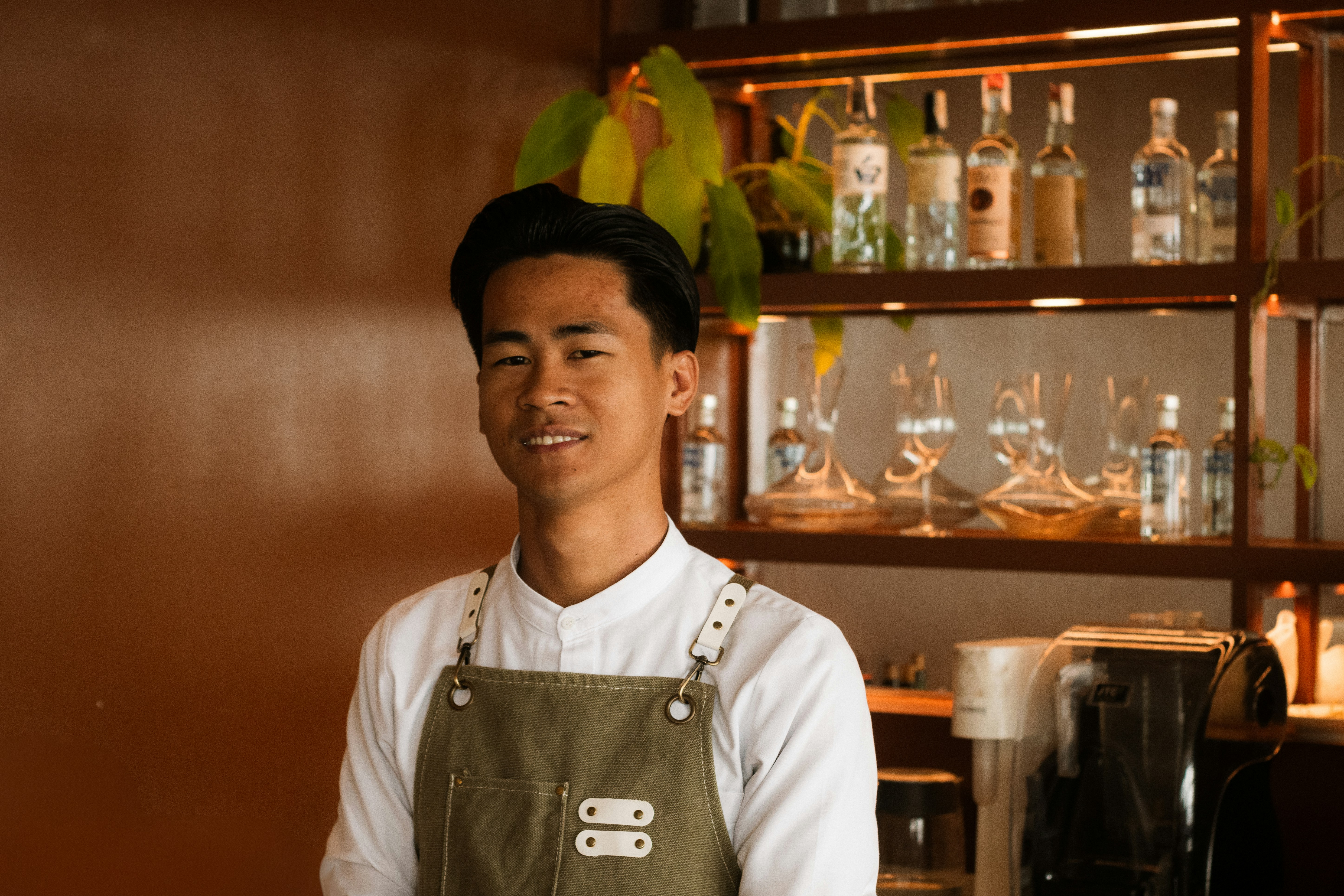 A bartender smiles in front of his bar.