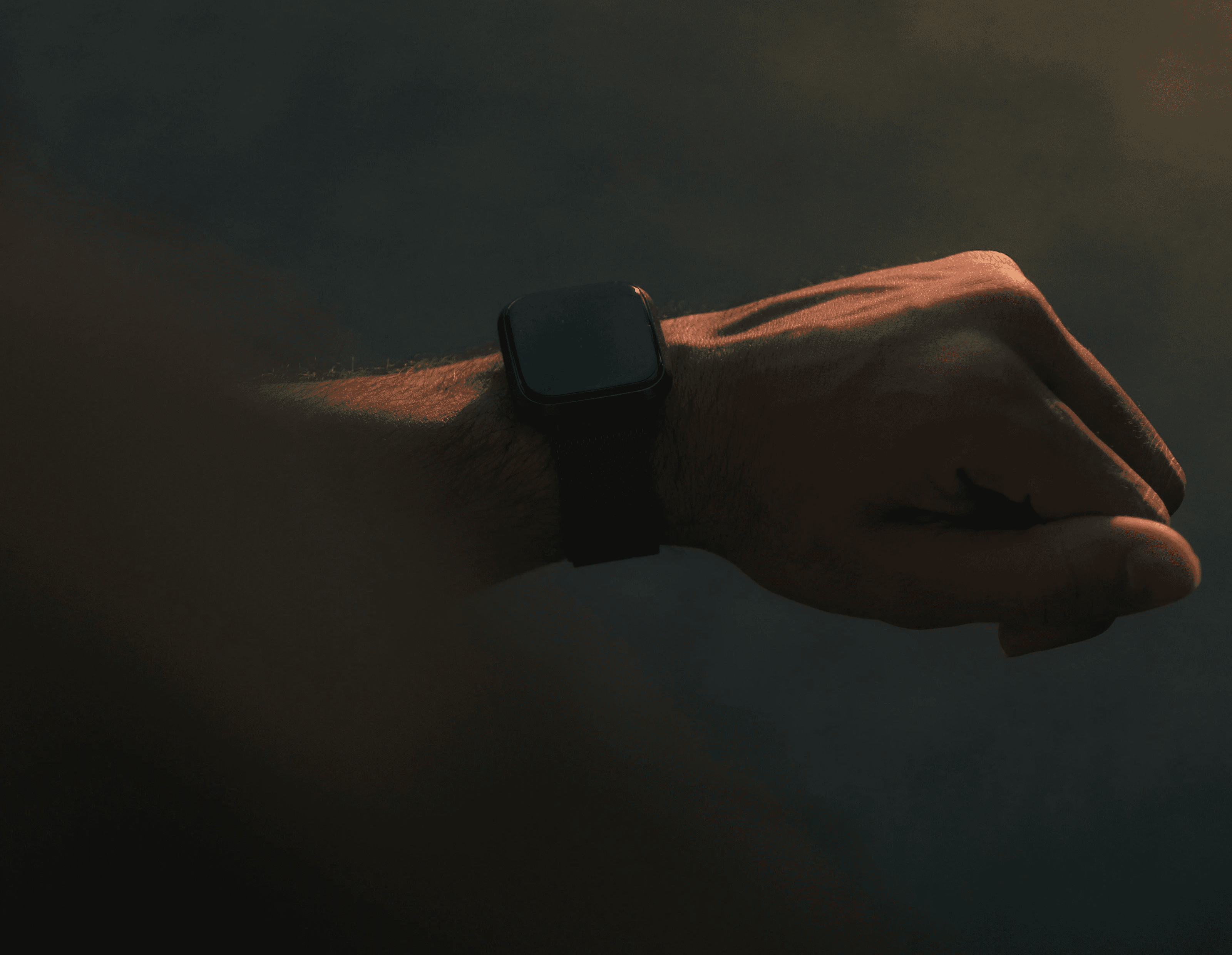 person wearing round black smartwatch