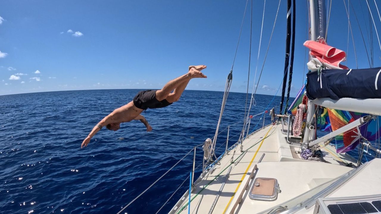 Noa from noathewhale jumping off his sailboat into the ocean