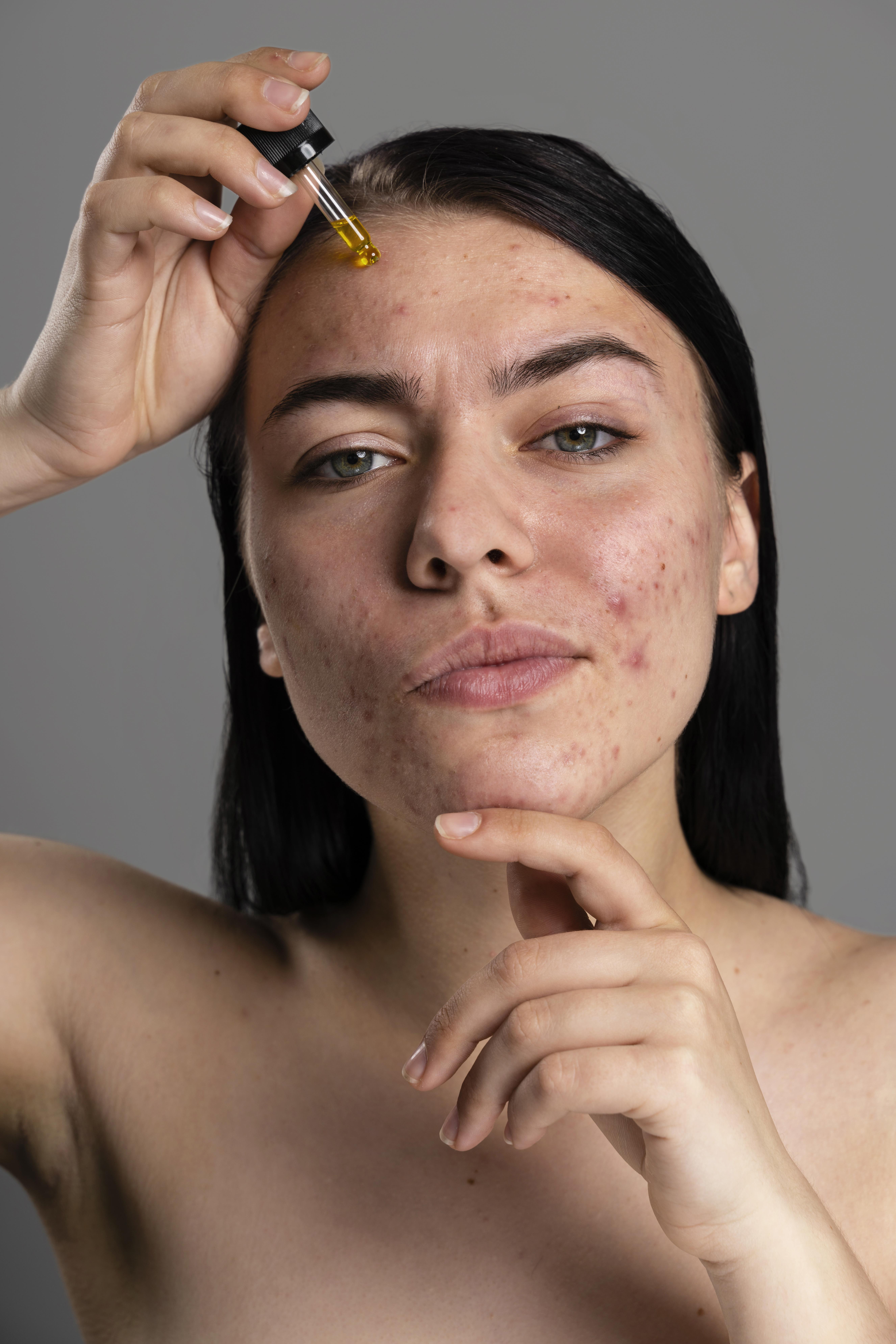 A woman lying down with a towel wrapped around her head, her face glowing with facial oil. She has a peaceful expression, enjoying a skincare treatment.