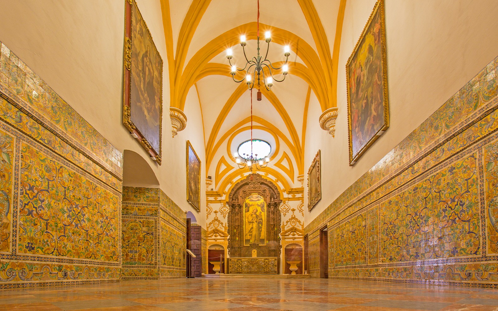 Pasillo con azulejos ornamentados y arcos en el palacio gótico, Alcázar de Sevilla.