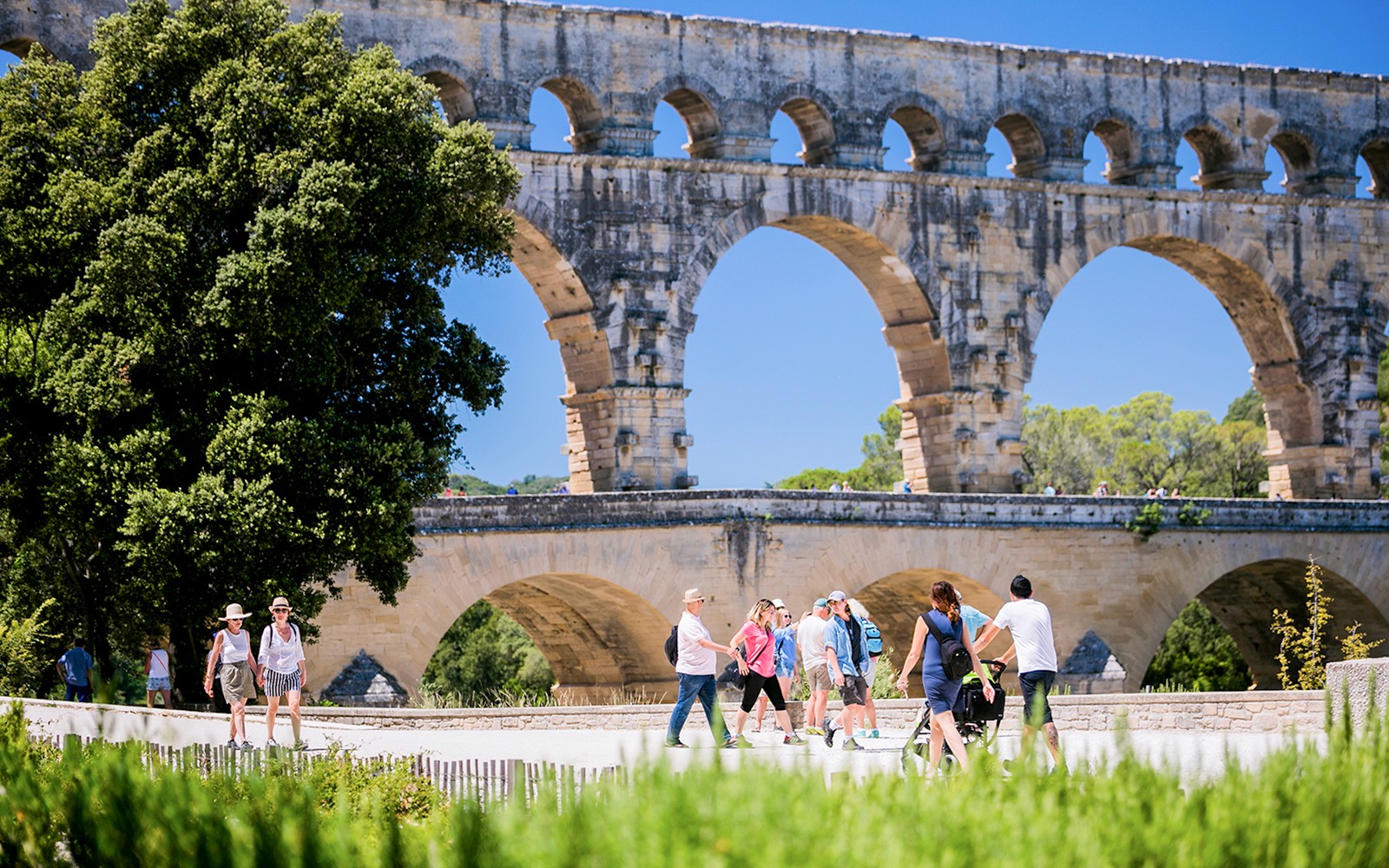 Tourists walking near the Pont du Gard aqueduct in Provence, France.