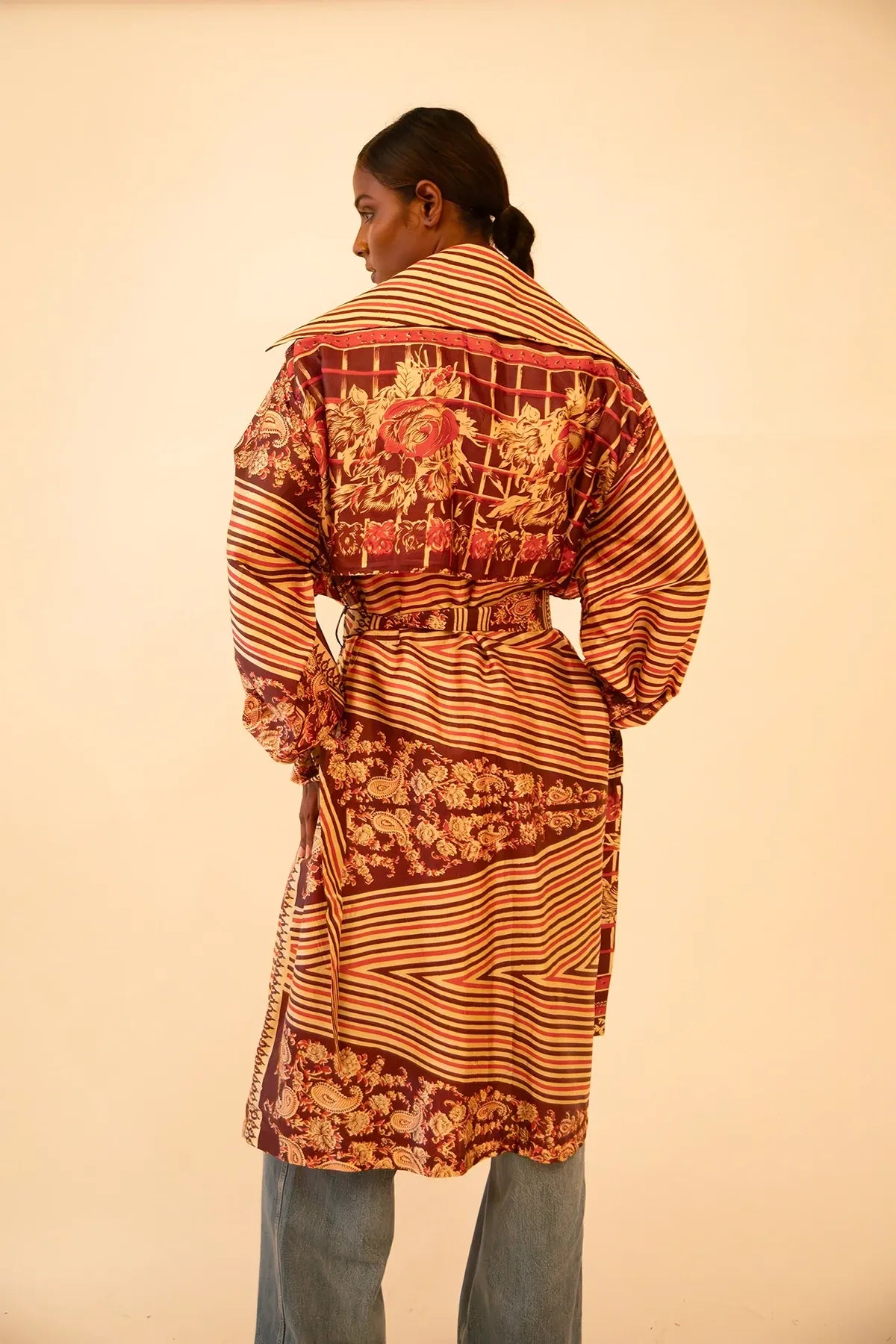 Rust-colored silk trench coat crafted from vintage fabric, featuring a relaxed fit, self-tie belt, and no inner lining, celebrating lightweight layering and conscious design.