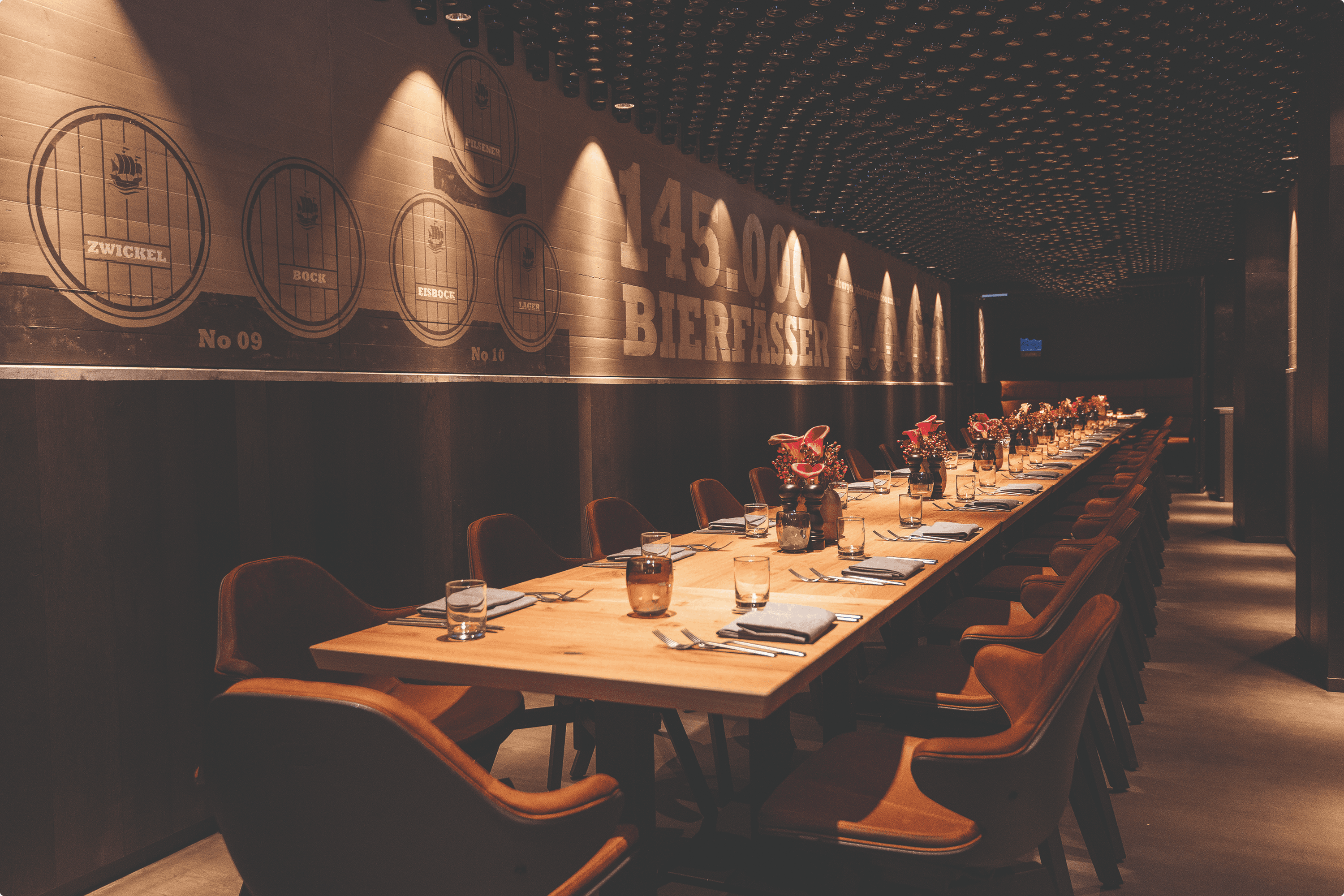 Long wooden table set with place settings and floral centerpieces.