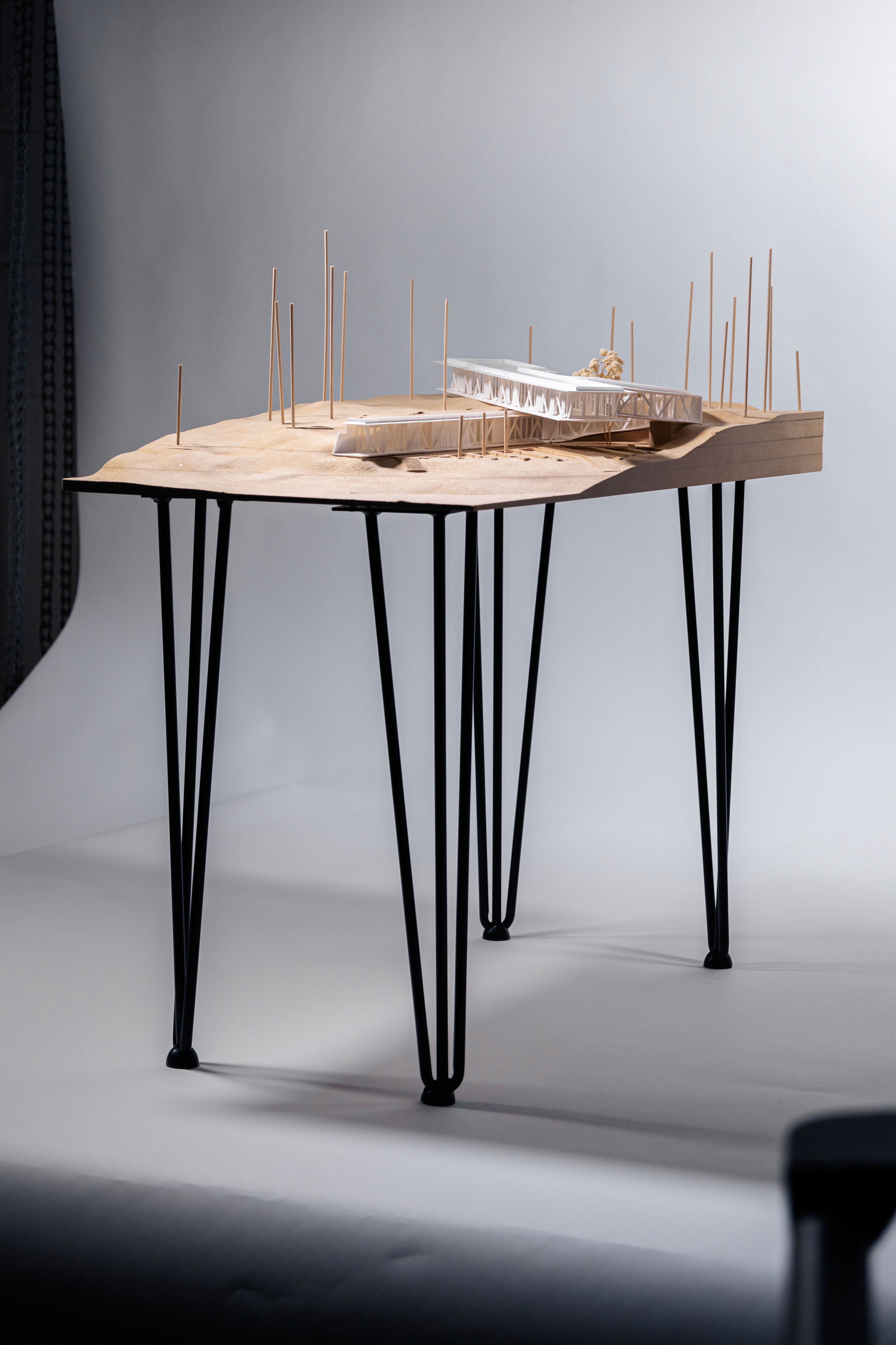 Physical concept model milled out of mdf with a 3D printed massing and steel legs.