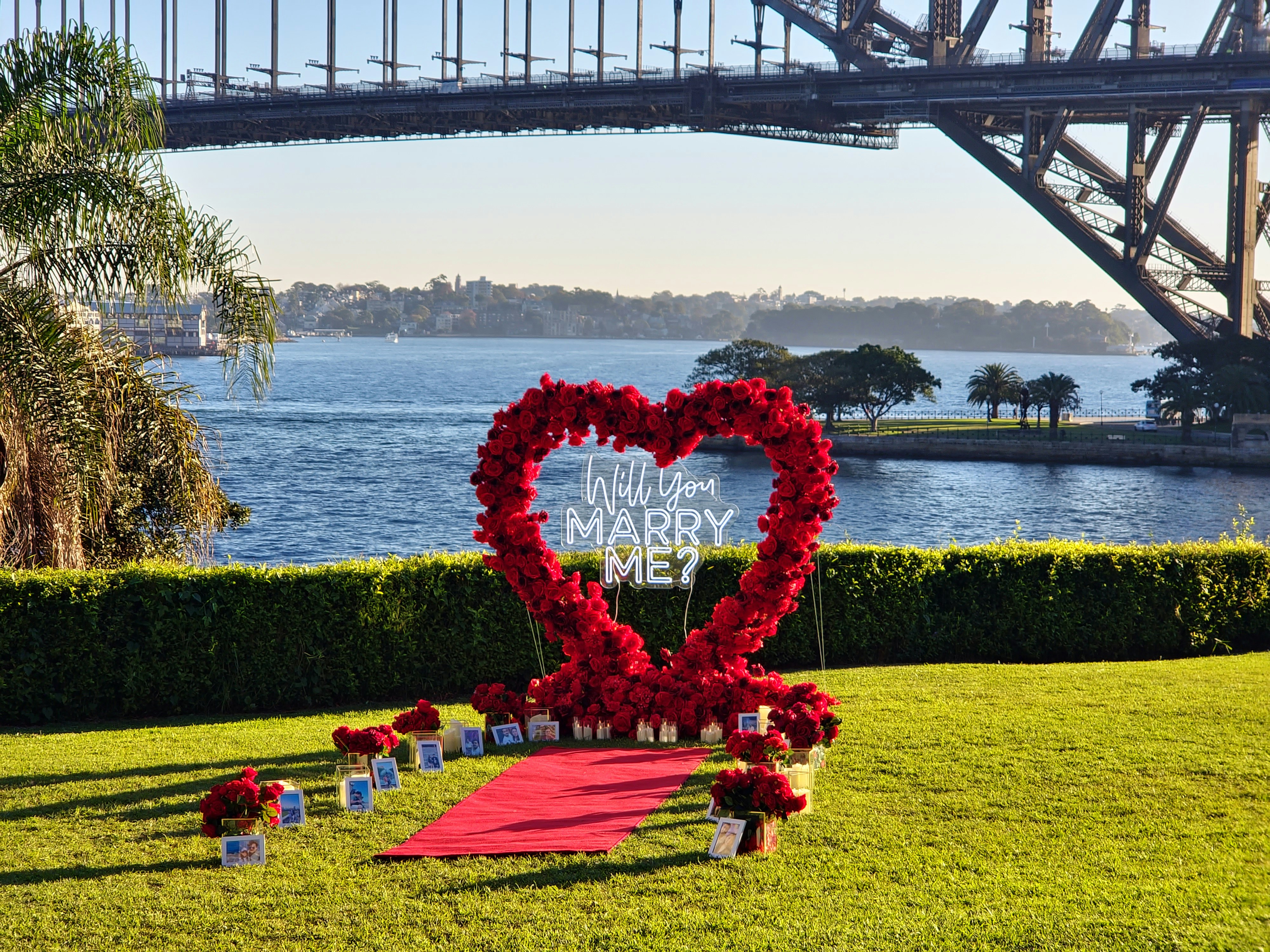 a heart shaped wreath on a red carpet in front of a bridge