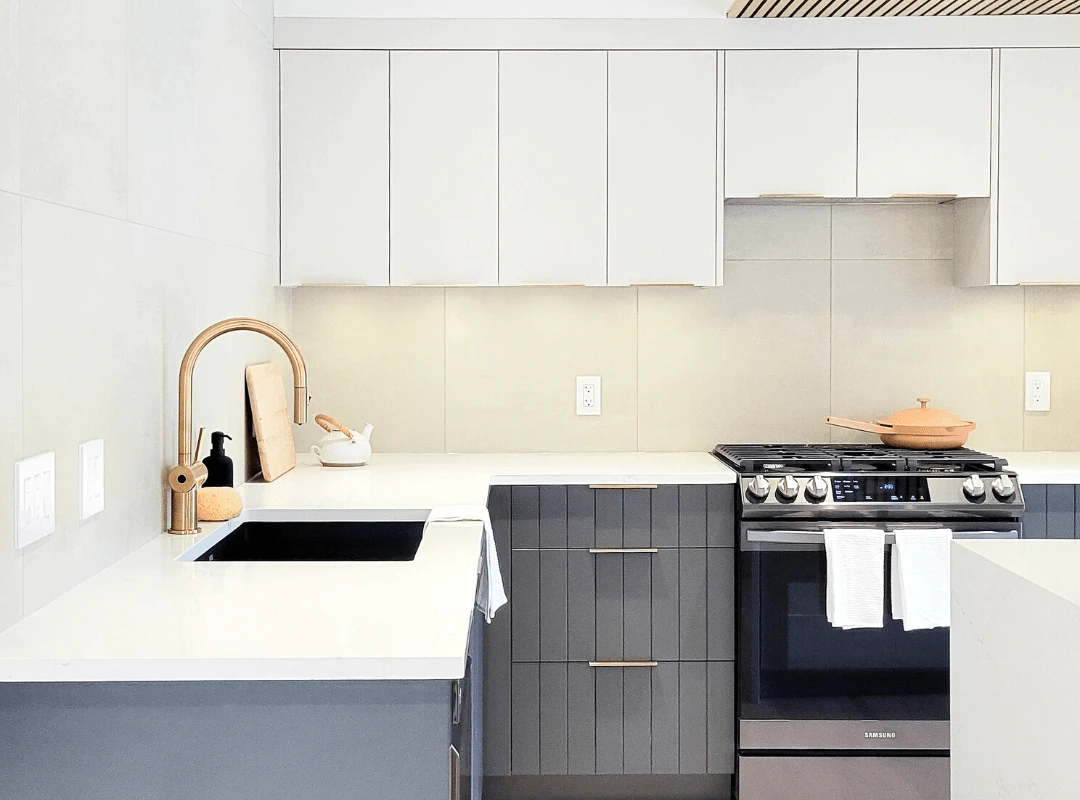 Image of Modern kitchen design with white countertops, gray cabinets, and luxurious gold accents by KHD Homes.