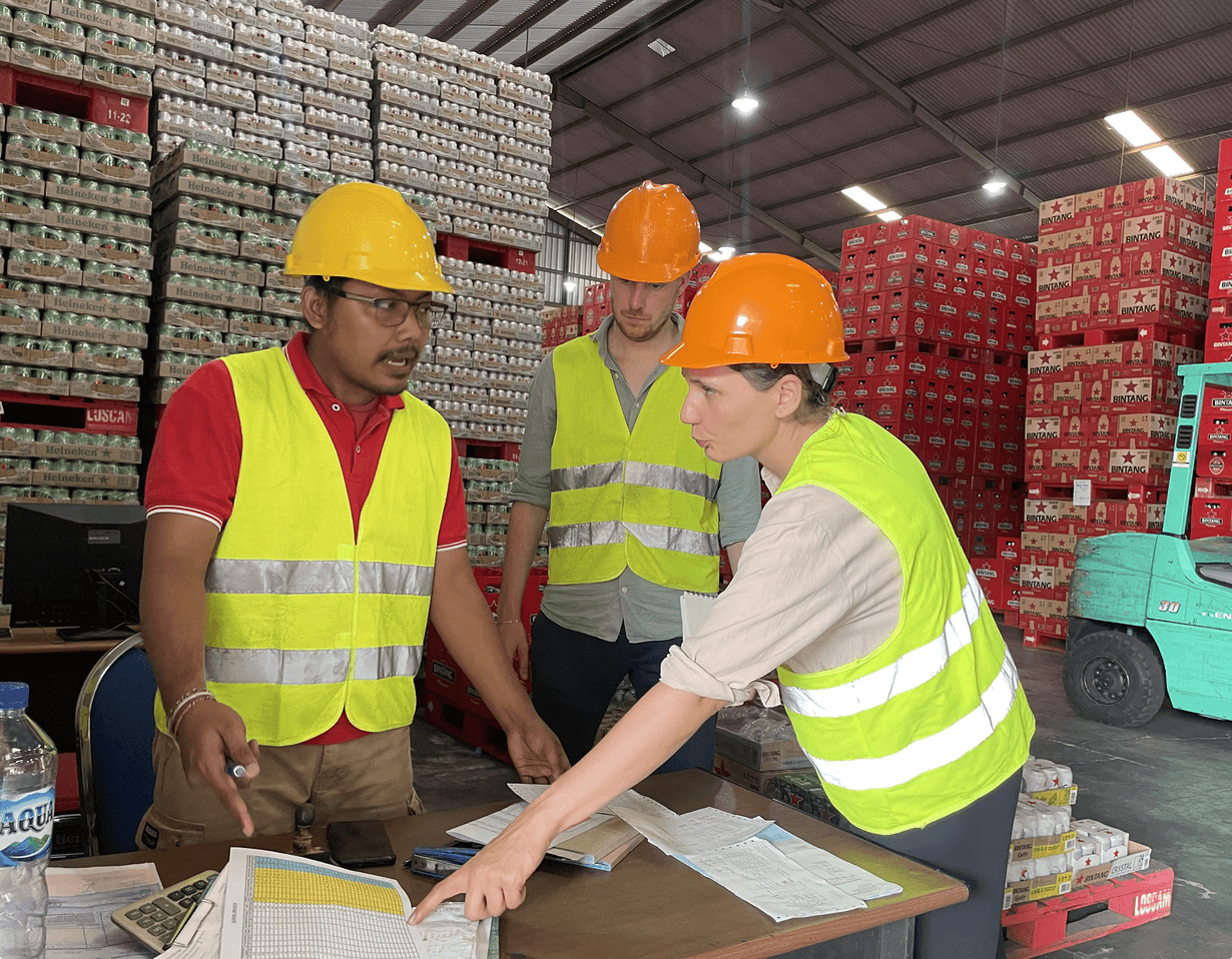 Distributor warehouse workers reviewing paper-based orders at a depot in an emerging market