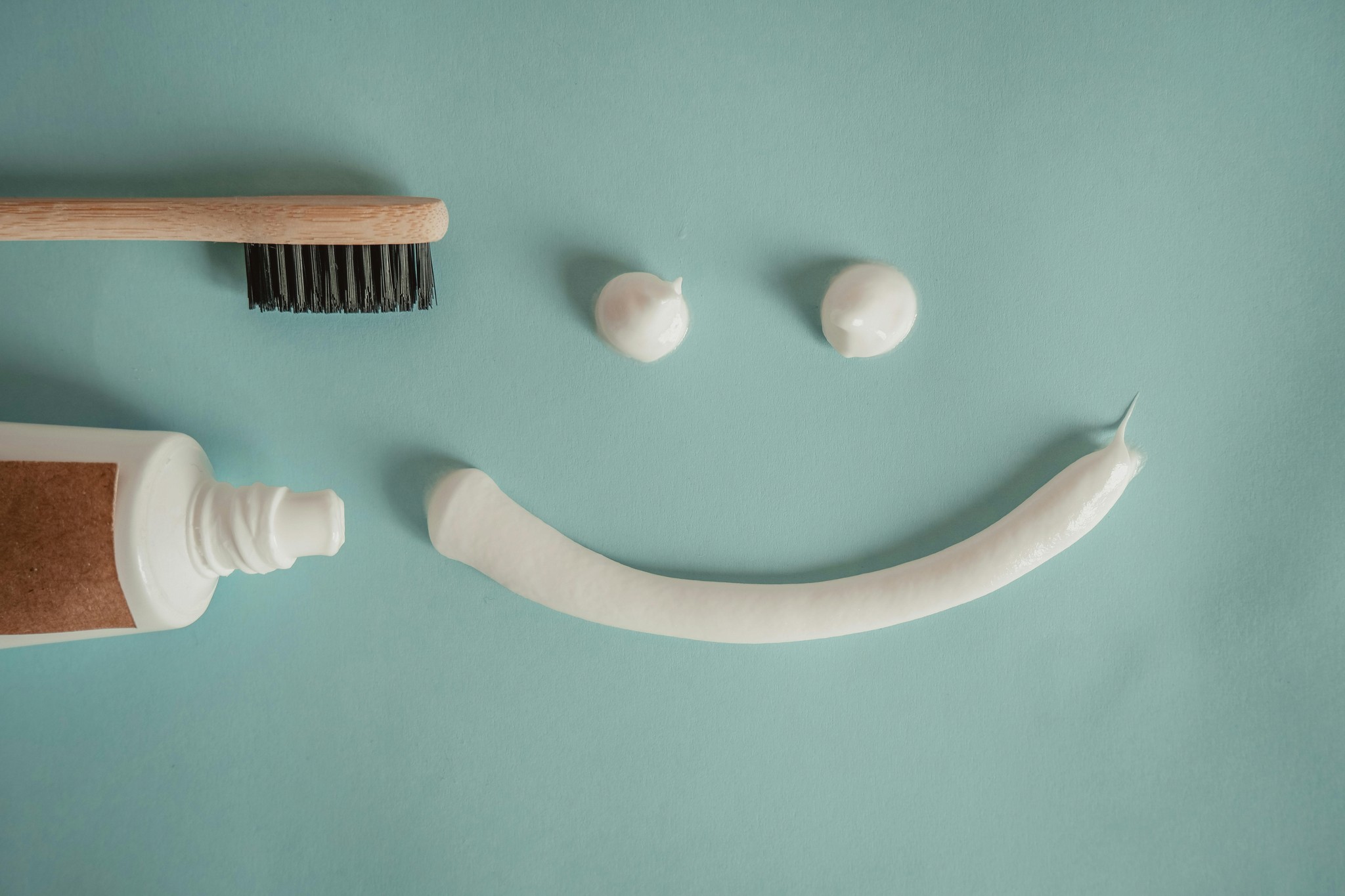 Picture of a tube of toothpaste, toothbrush and a smiley-face made of toothpaste