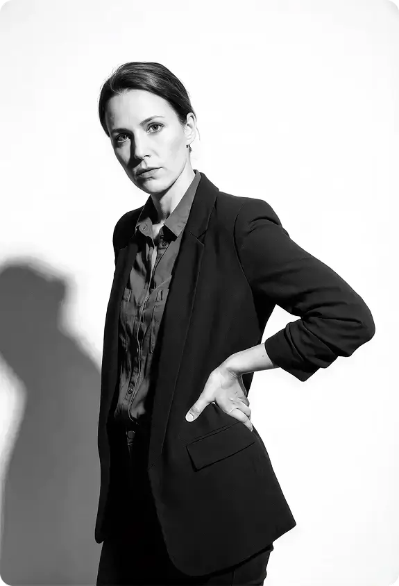 Portrait éditorial d'une entrepreneure en tailleur, posture affirmée, noir et blanc.