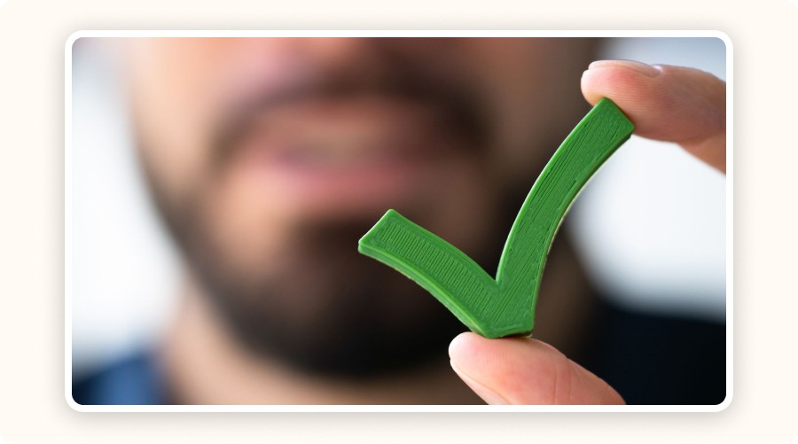 Person holding green checkmark symbol indicating approval or accuracy