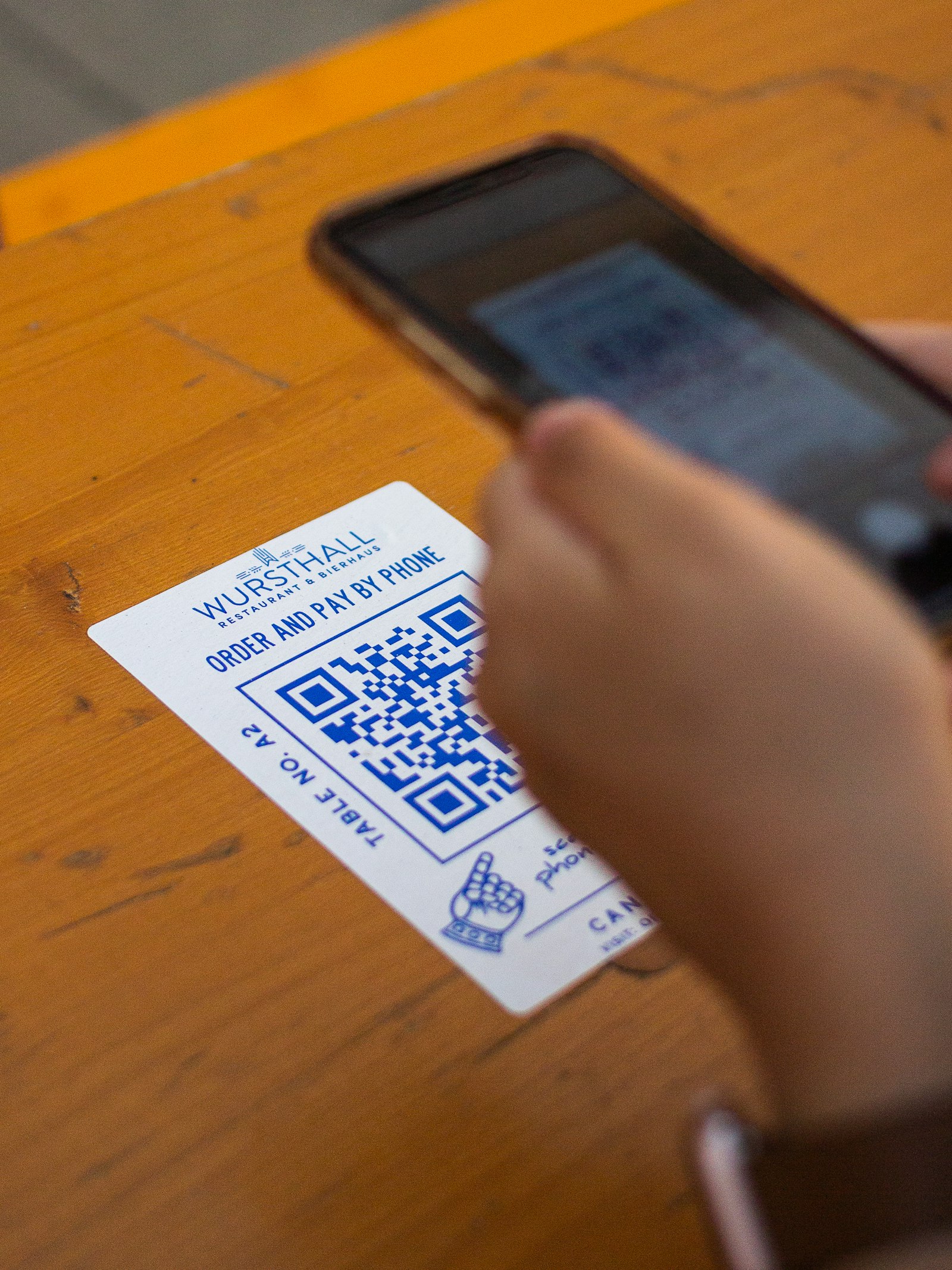 Persona sosteniendo una tarjeta blanca y negra junto a un código QR
