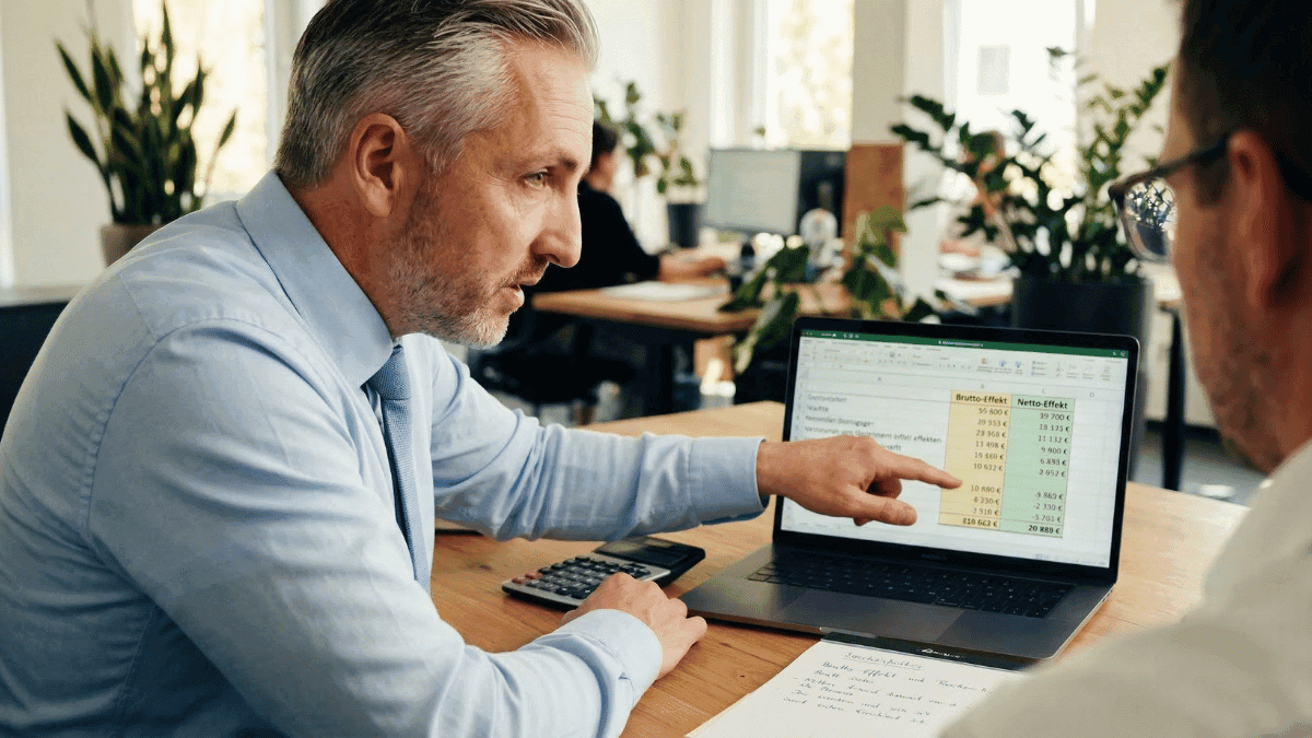 Hannes Weindorf zeigt einem Geschäftsführer die Steuervorteile der betrieblichen Altersvorsorge am Laptop