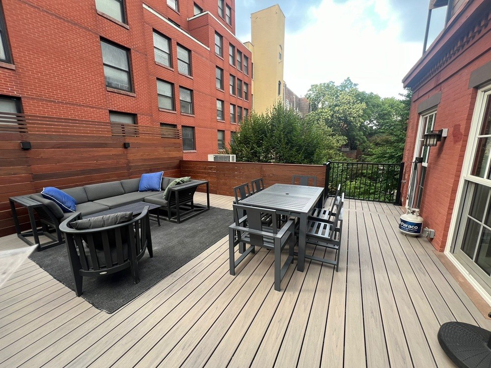 Elegant elevated deck with Trex Transcend® Lineage Island Mist with Trex Signature Railing, Ipe privacy fence and lighting by Jewel Construction Brooklyn Heights