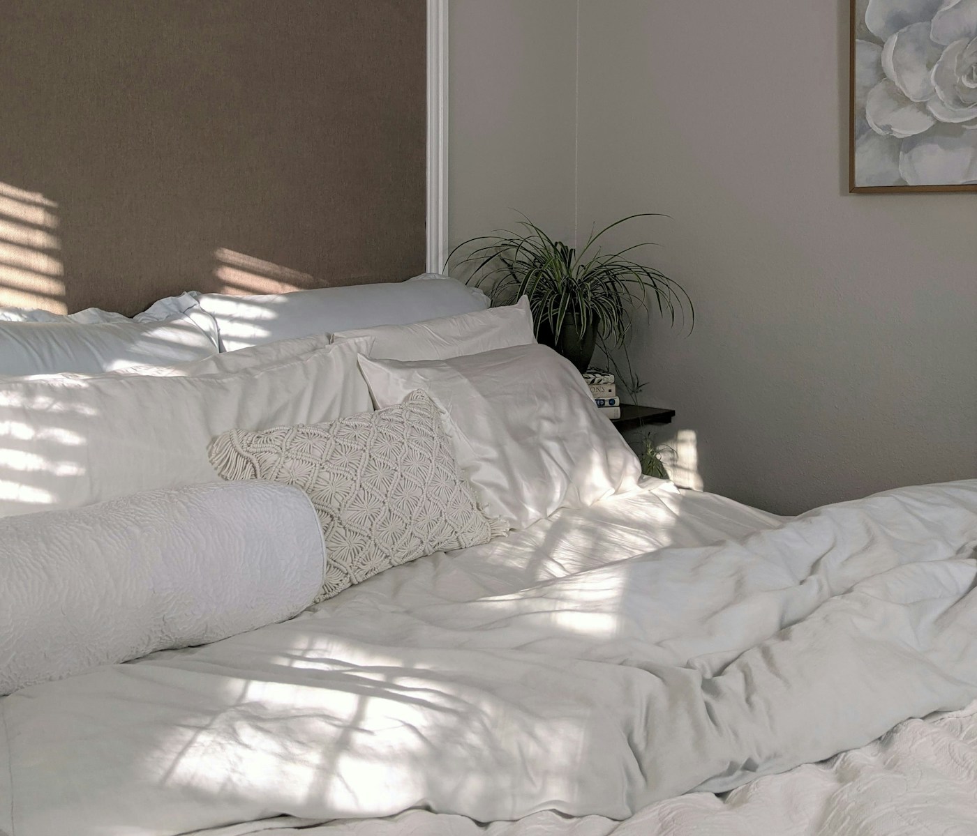 White bed linen near green plant