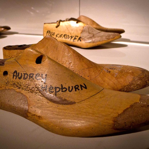 展出的两只木制鞋楦上用黑色记号笔标注了名字：前景为“奥黛丽·赫本”，背景为“艾娃·加德纳”。