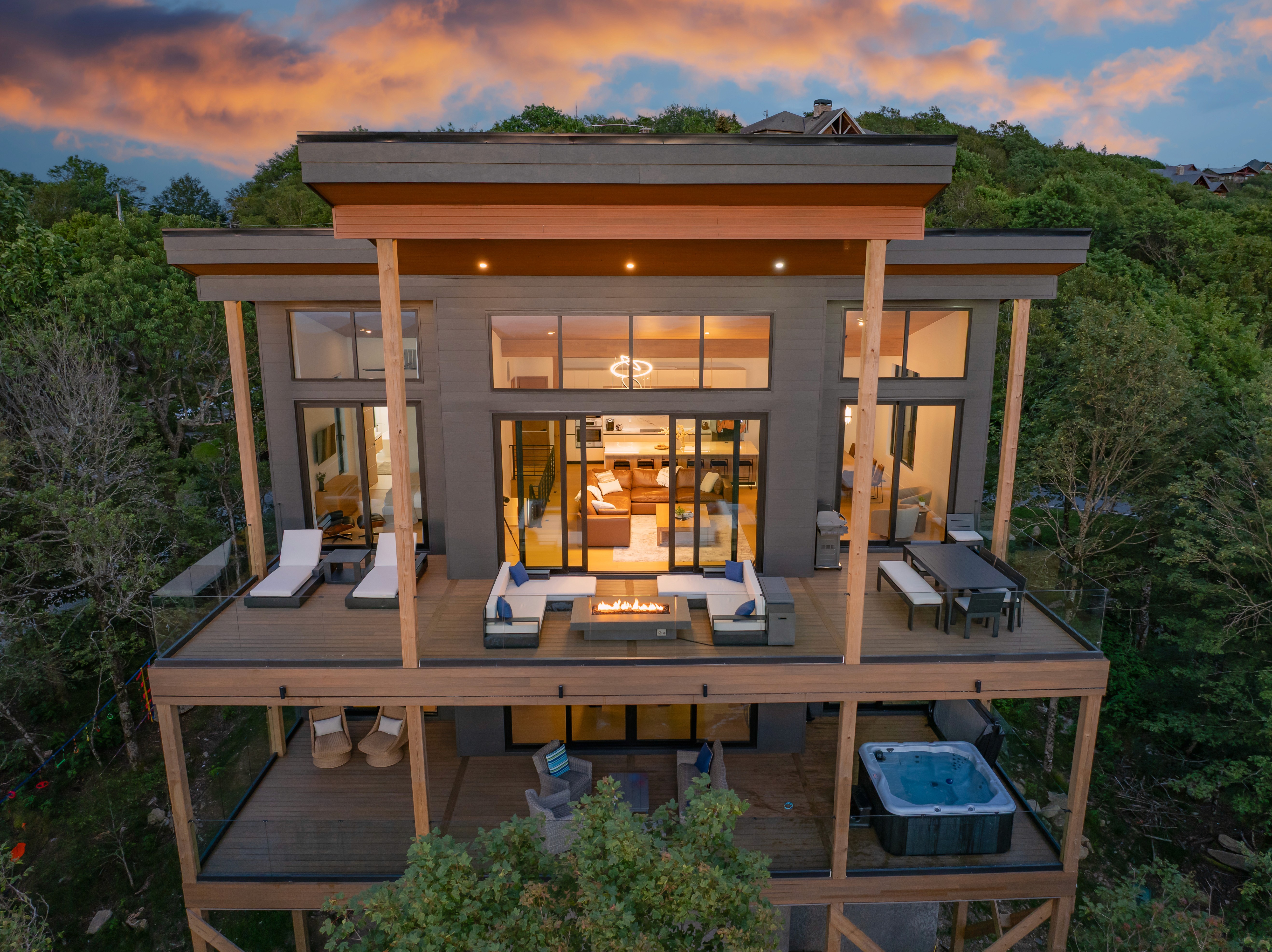 An intimate aerial view focused on the sprawling deck and main living space of the contemporary mountain retreat