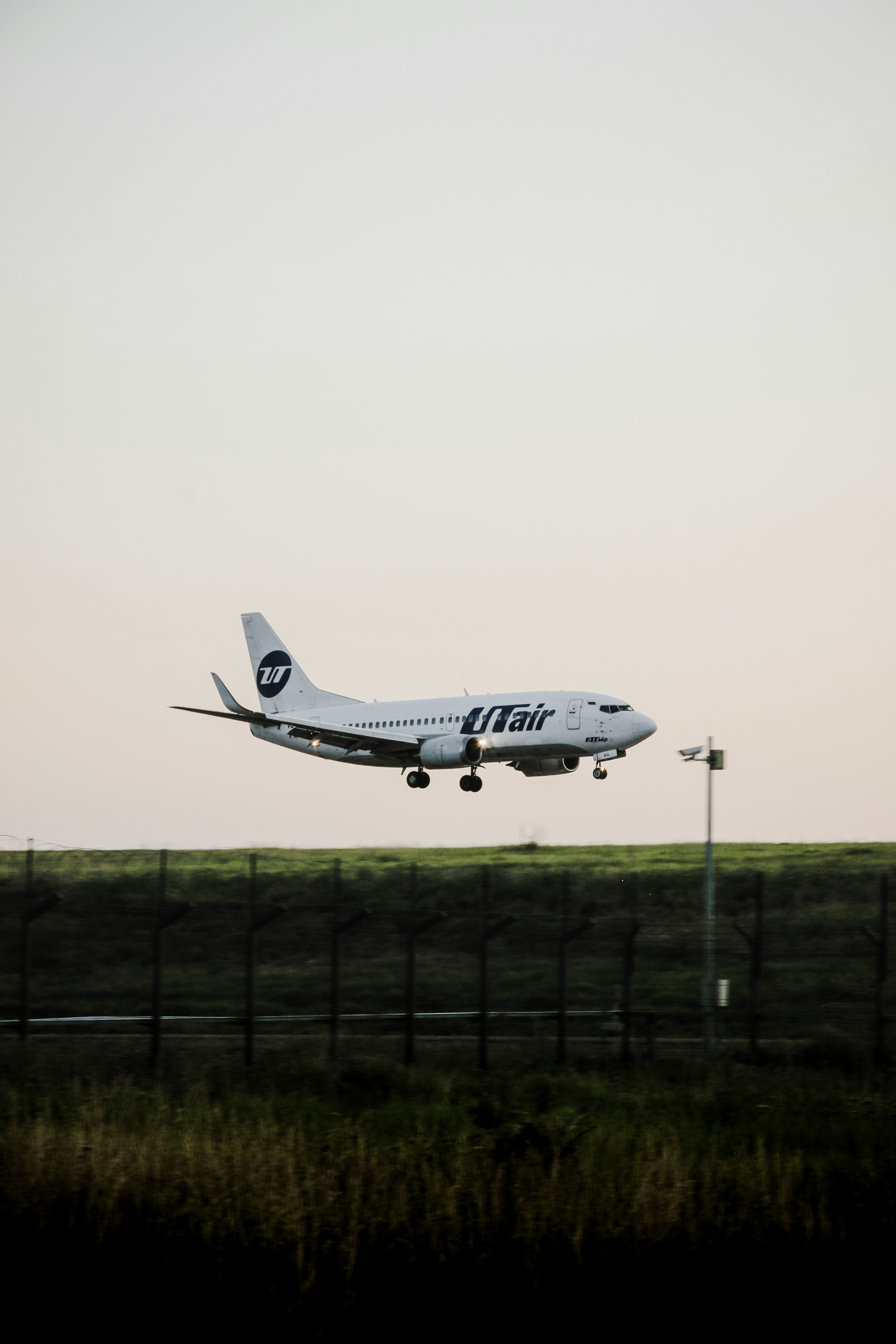 A white airplane with "utair" logo landing.