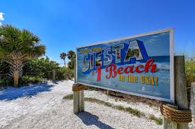 Colorful 'Siesta Beach' welcome sign on the sandy entrance to Siesta Key