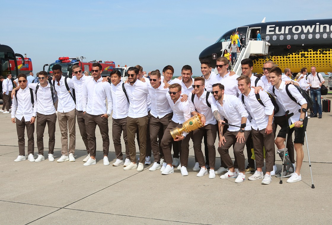 BVB-Spieler posieren mit Pokal auf dem Rollfeld am Flughafen Dortmund