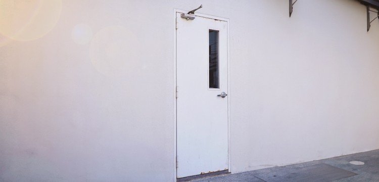 White metal commercial door featuring a small glass window, exemplifying a practical and secure design.