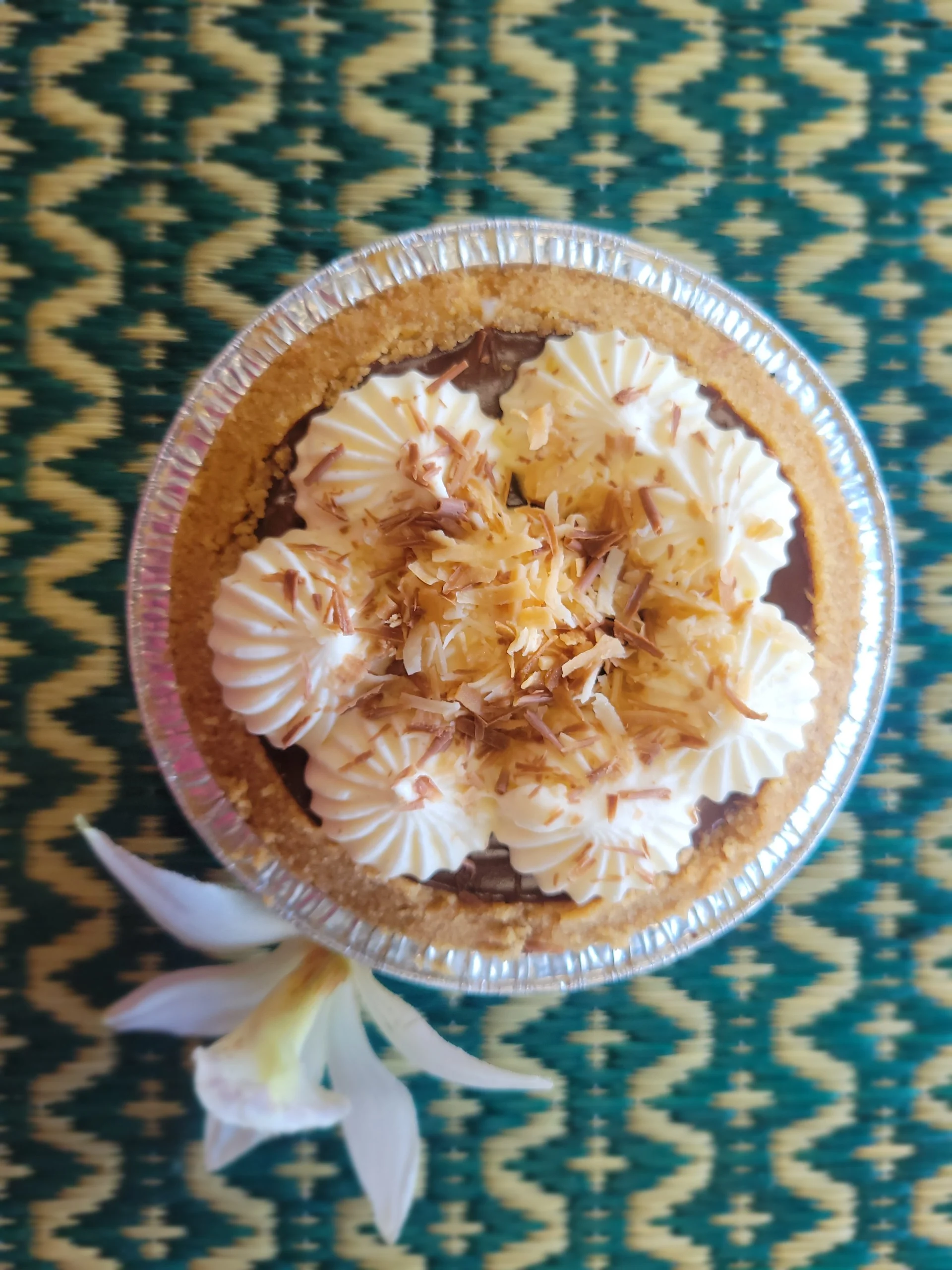 Whole Chocolate Haupia Pie decorated with toasted coconut flakes.