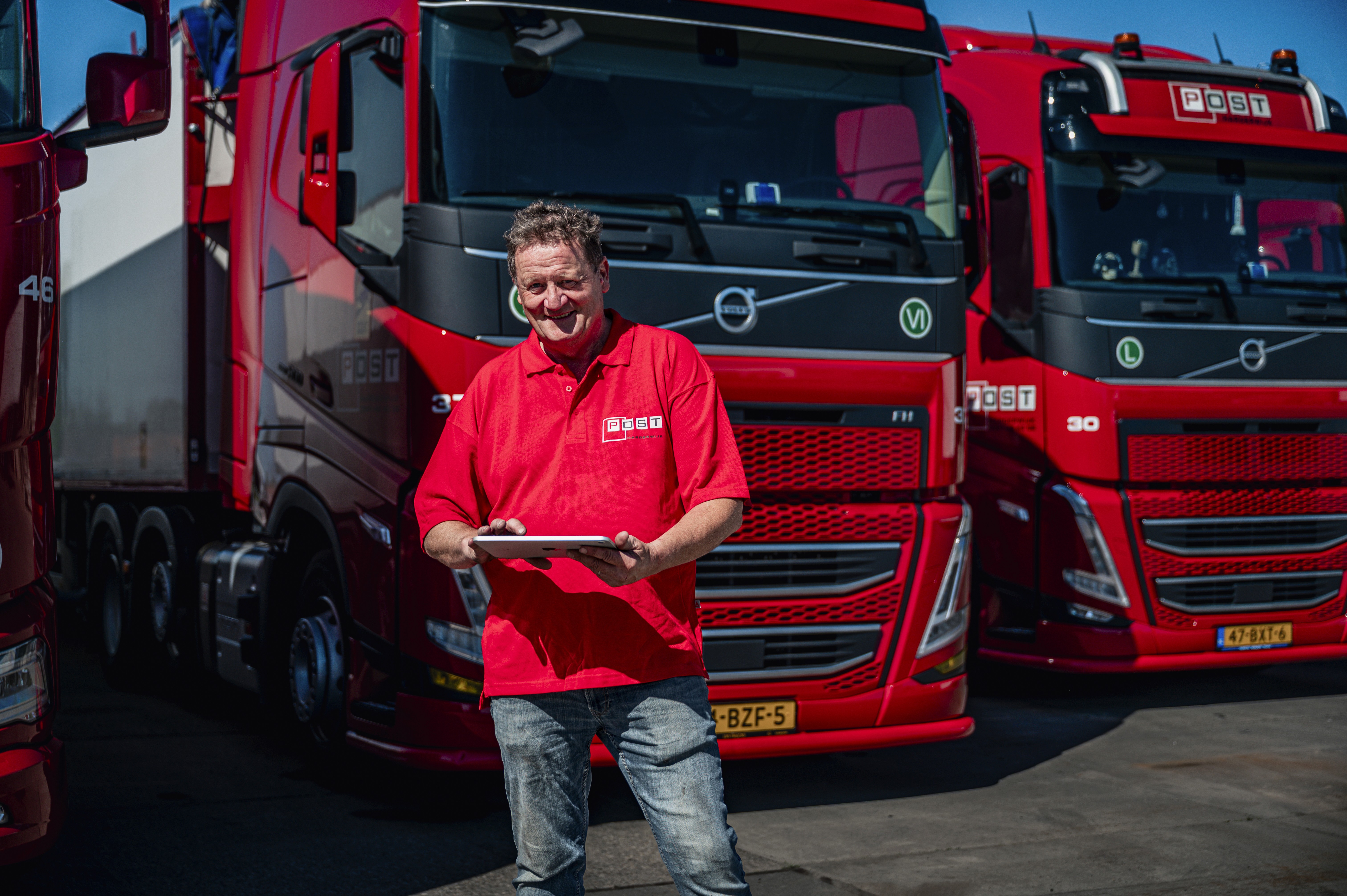Chauffeur naast vrachtwagen Post Handel en Transport