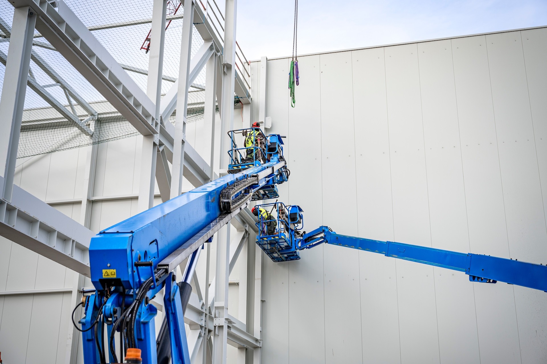 Blauwe hoogwerkers bij staalconstructie- Steeg en van Harten