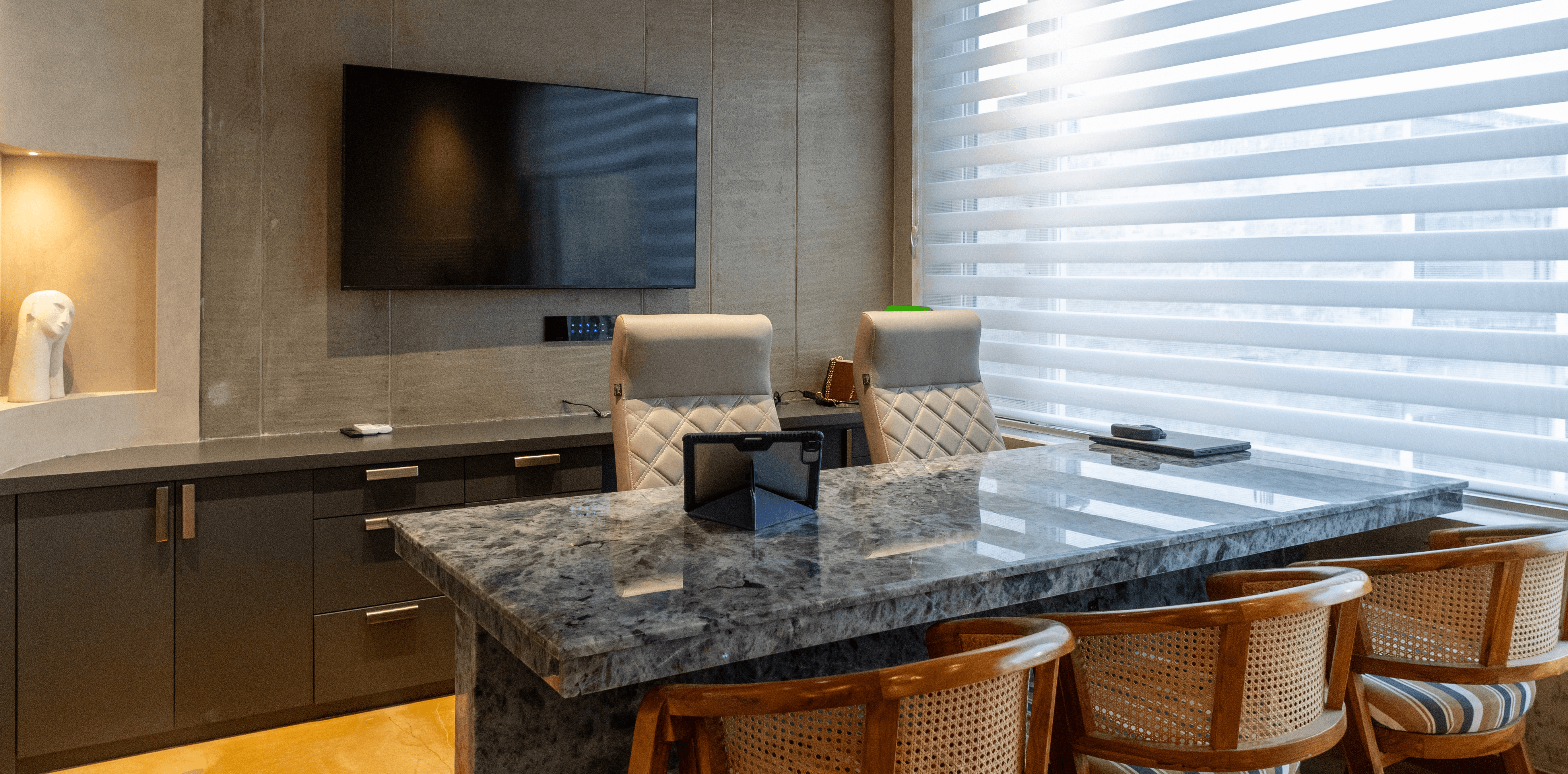 Minimalist living space featuring oak flooring, timber wall panels and panoramic windows with natural light.