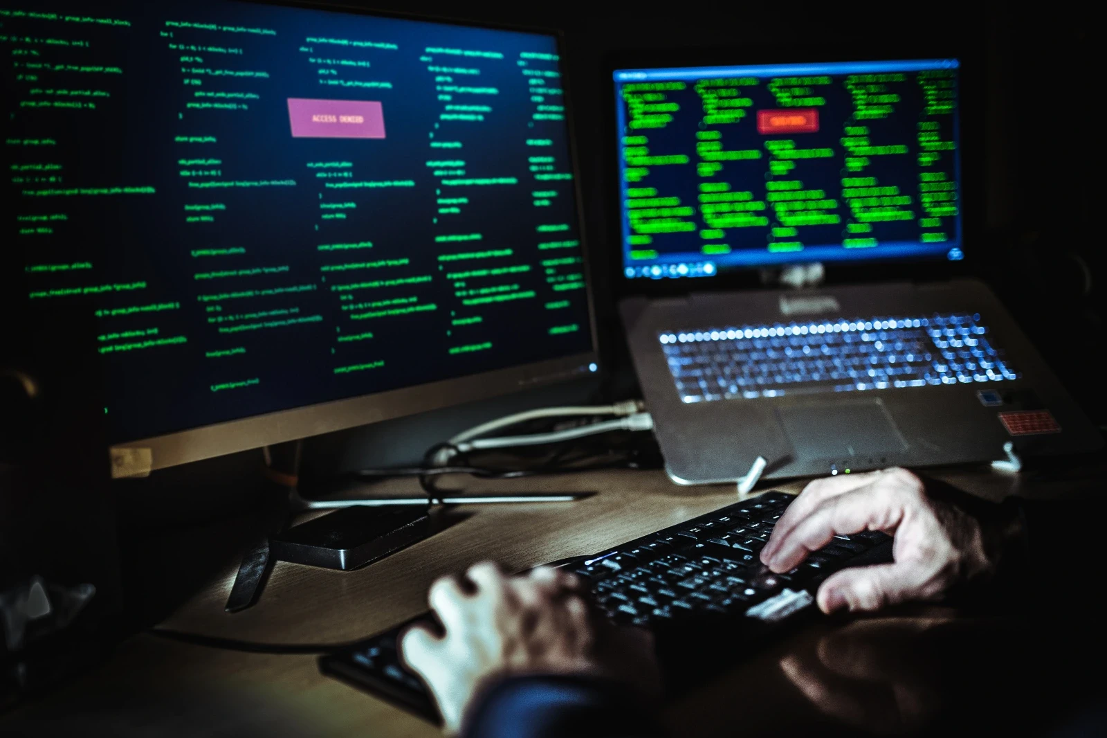 Monitore mit „Access Denied“ und Code als Hinweis auf Cyberangriff