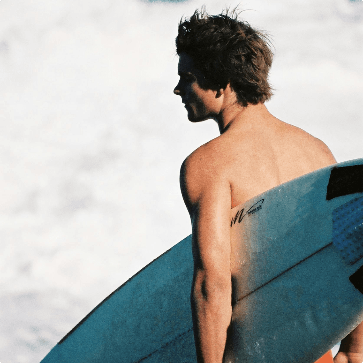 A man stading with Surfboard